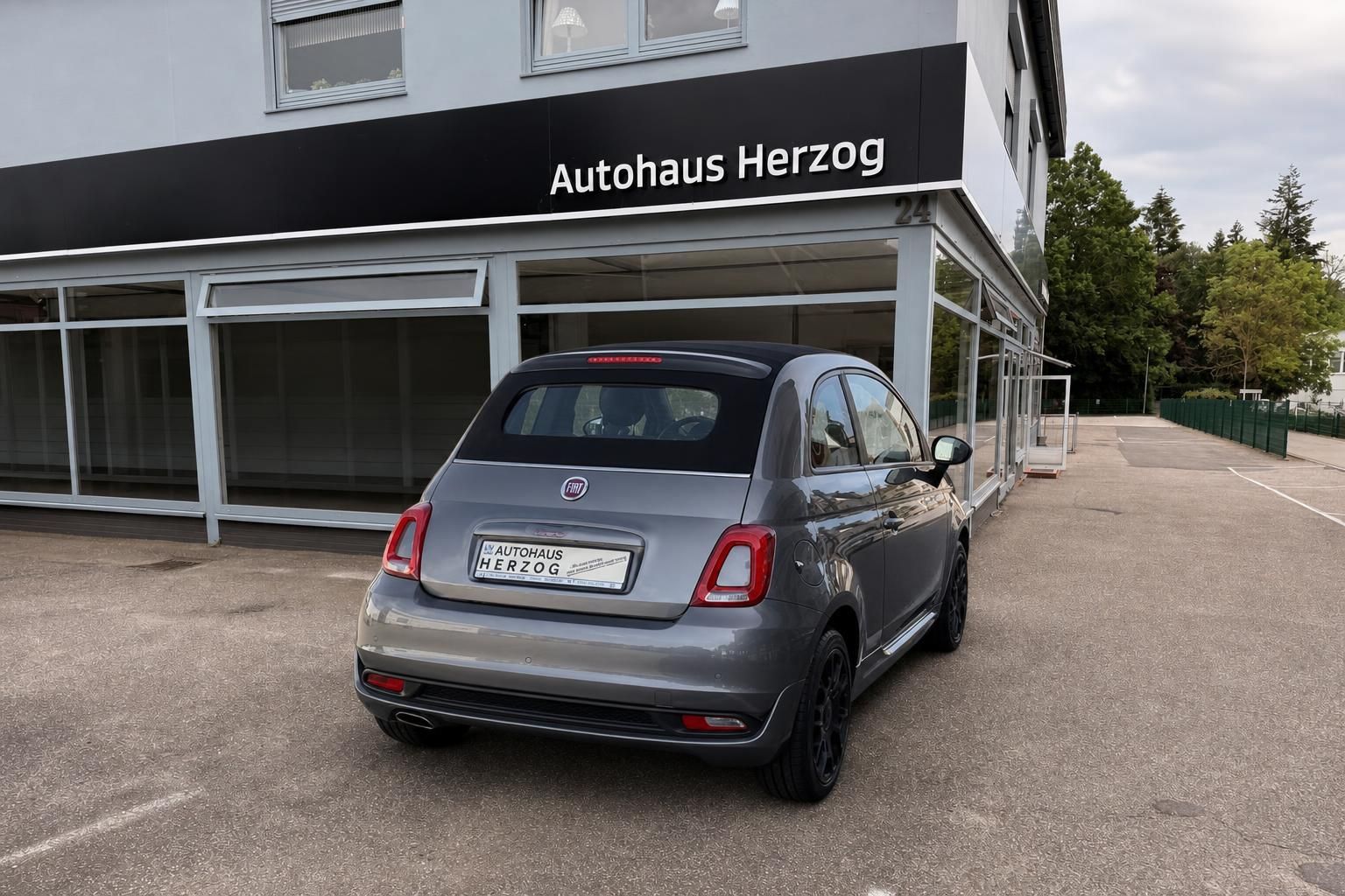 Fiat 500 grau Heckansicht seitlich vor Autohaus Herzog Fassade
