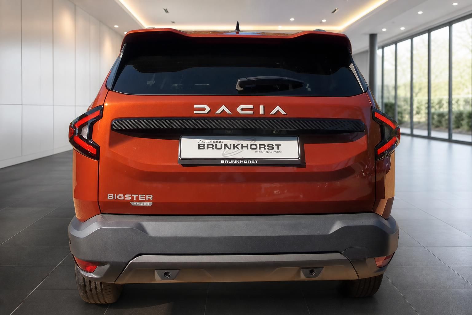 Dacia Bigster Hybrid Heckansicht in Orange mit Dacia Schriftzug