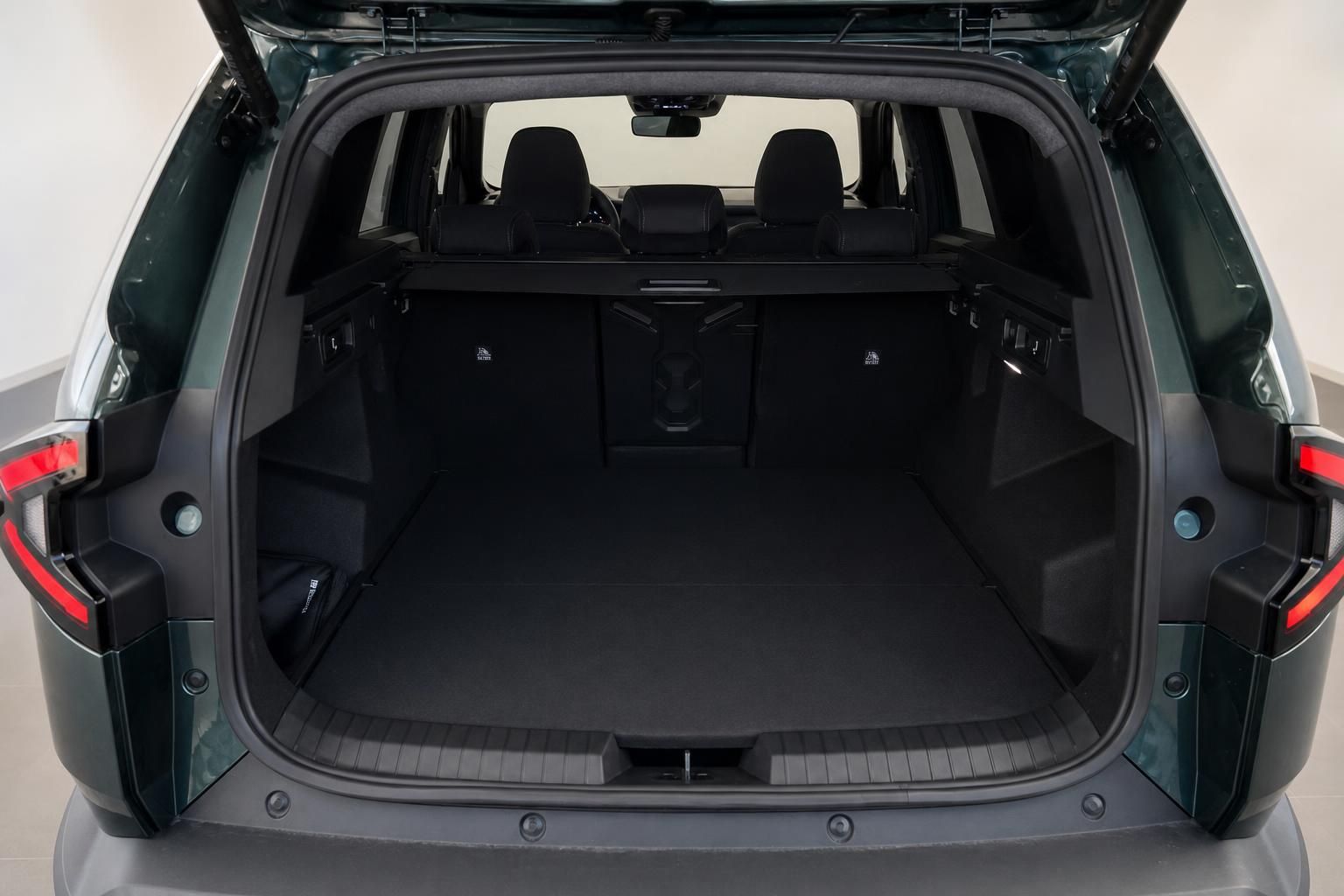 Geräumiger Kofferraum eines grünen SUV mit umgeklappten Rücksitzen und schwarzer Ausstattung