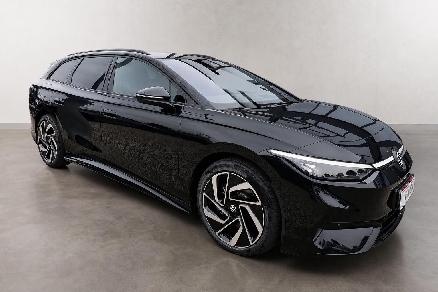 VW ID.7 Tourer schwarz, Frontansicht seitlich vor Wand