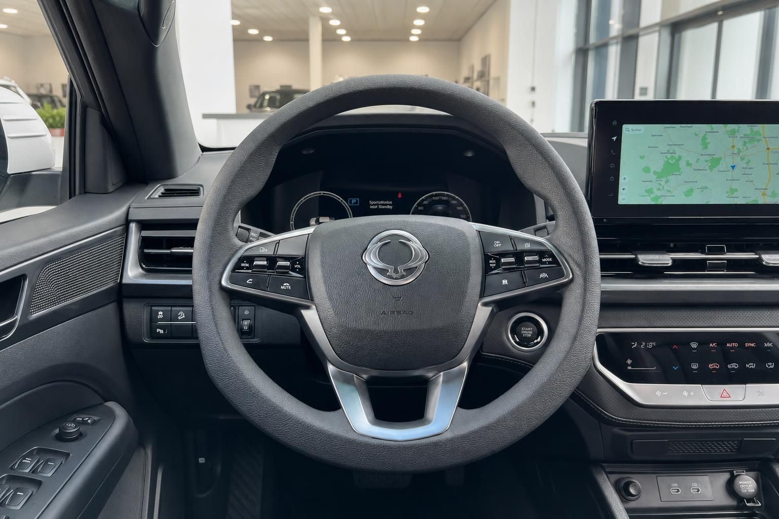 Modernes Fahrzeug-Cockpit mit Lenkrad, Instrumententafel und Navigationssystem im Innenraum