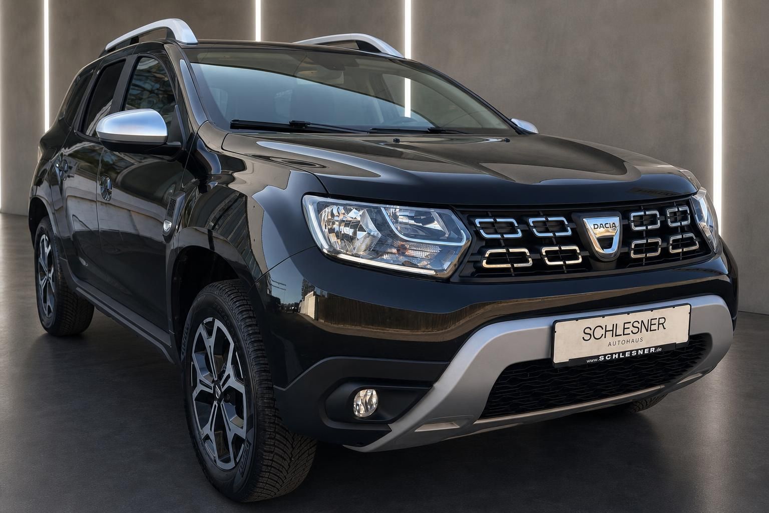 Dacia Duster schwarz SUV Frontansicht schraeg mit Dachreling