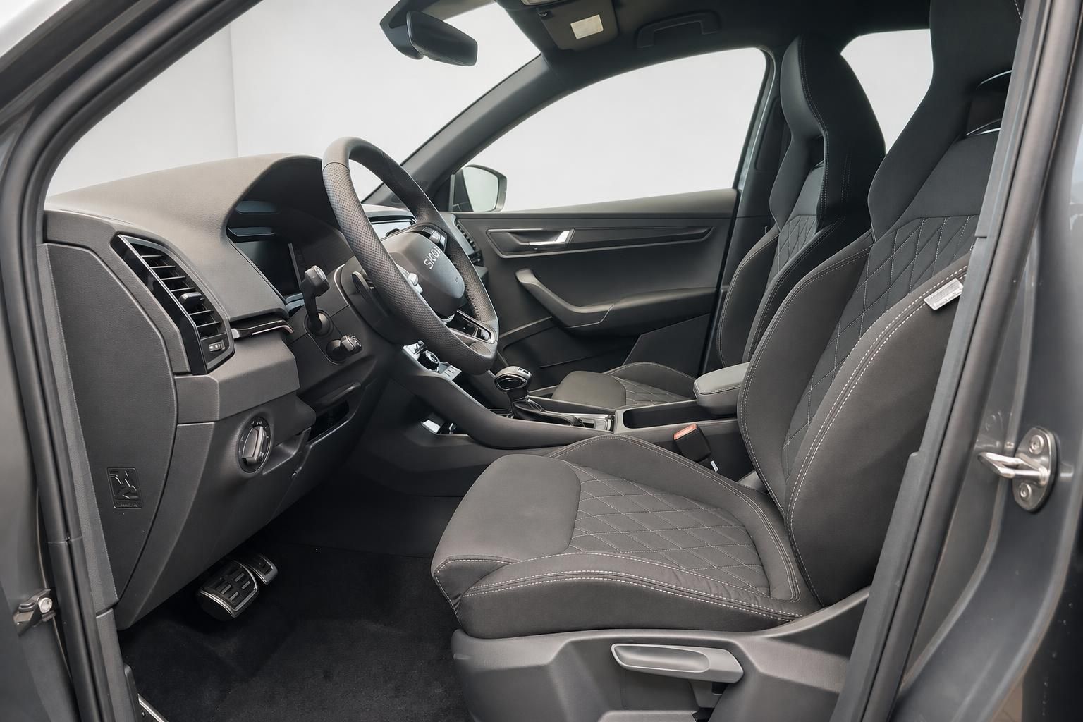 Škoda Fahrerseite mit Sportsitzen, Lenkrad und offener Fahrertür im Detail