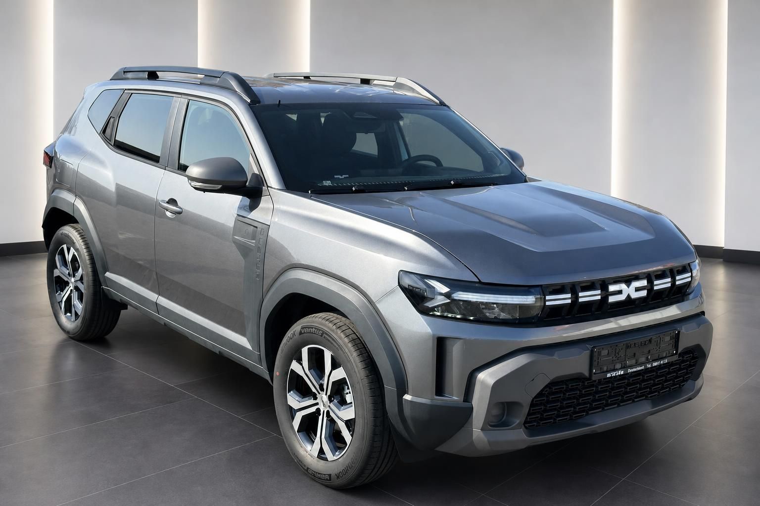 Dacia Duster SUV grau Schrägansicht vorne links im modernen Autohaus