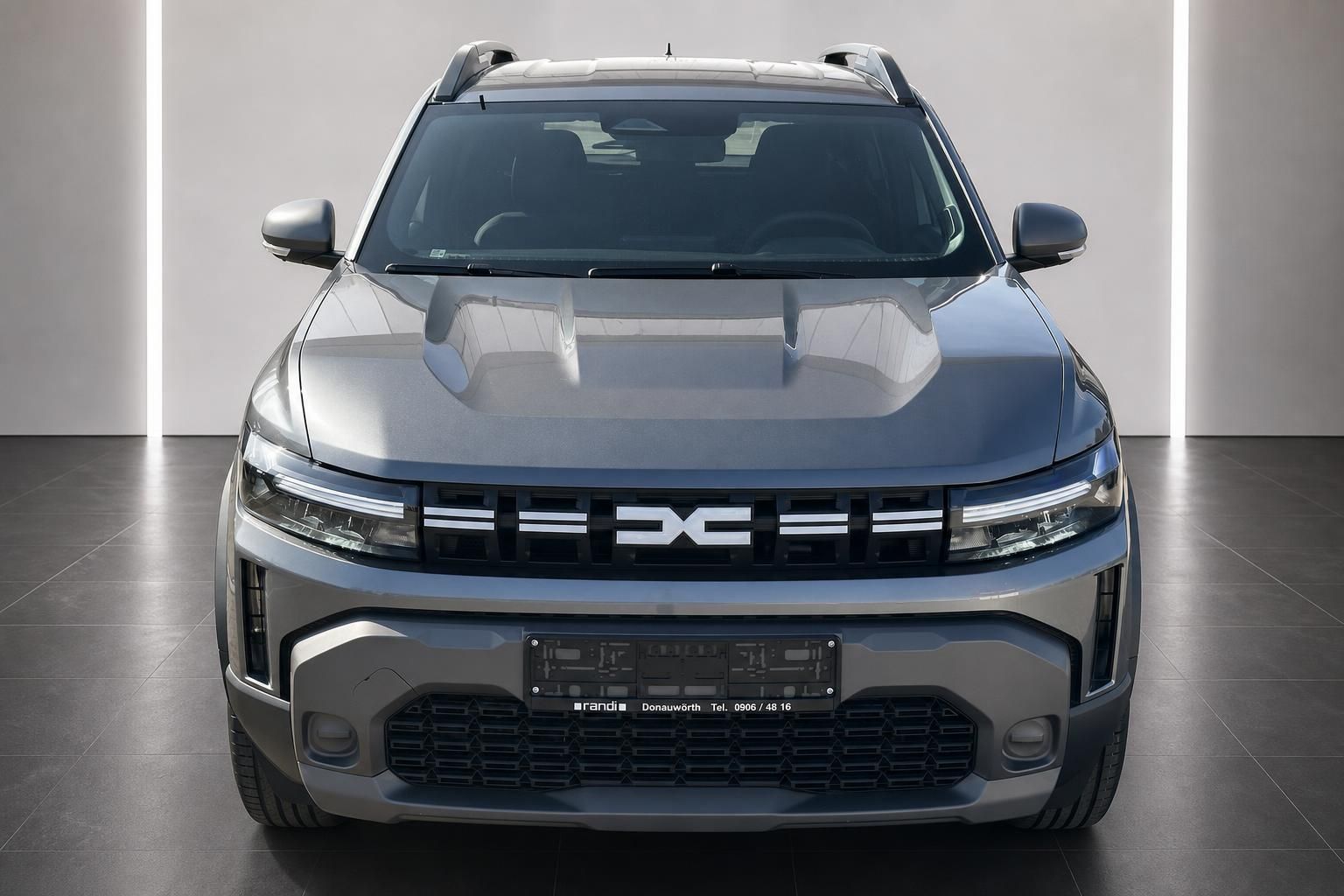 Dacia Duster SUV grau Frontansicht im Showroom mit Kennzeichenhalter