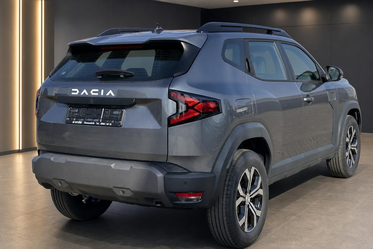 Dacia Duster SUV grau Heckansicht schräg in Fahrzeughalle