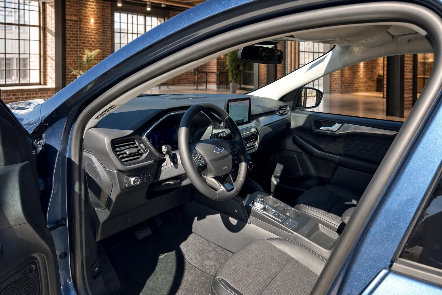 Ford Kuga Innenraum Fahrerseite – Lenkrad, Cockpit und Touchscreen aus geöffneter Tür