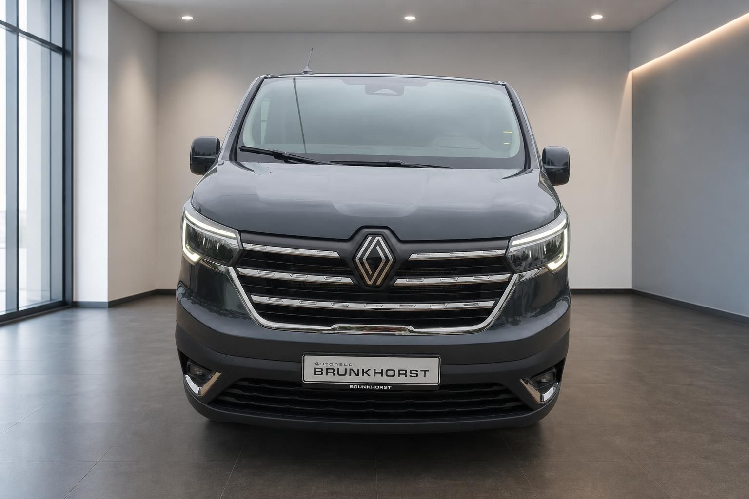 Renault Trafic Frontansicht in grau mit markanten LED-Tagfahrlichtern im Showroom