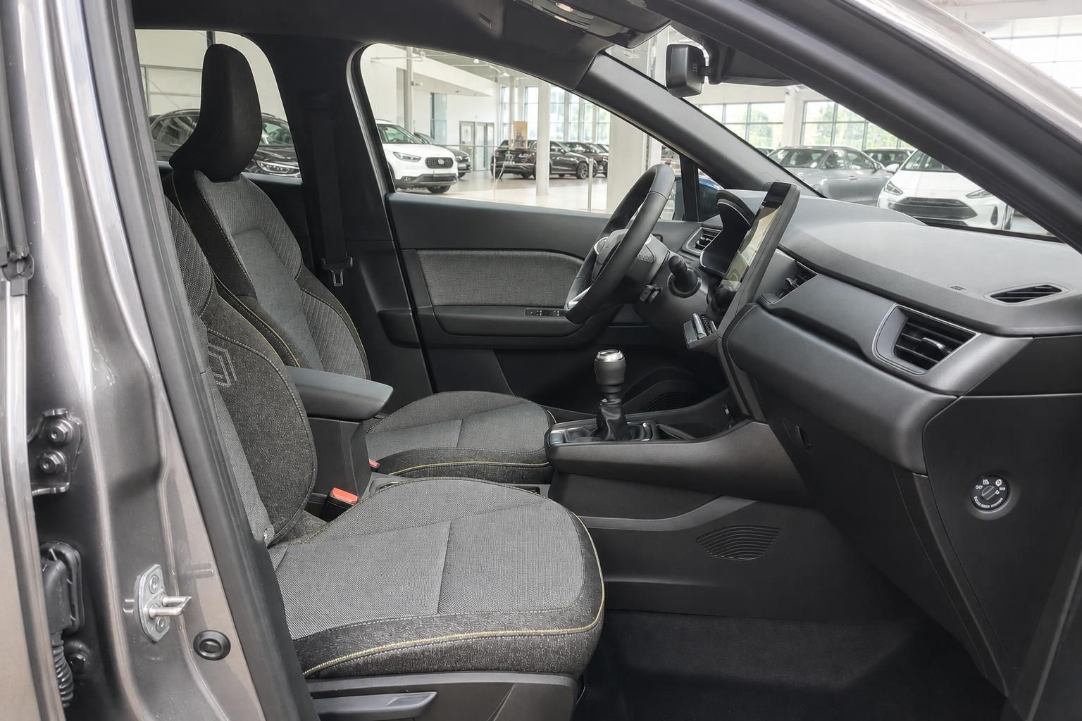 Fahrzeuginnenraum mit grauen Stoffsitzen und Armaturenbrett, Blick auf Vordersitze und Cockpit
