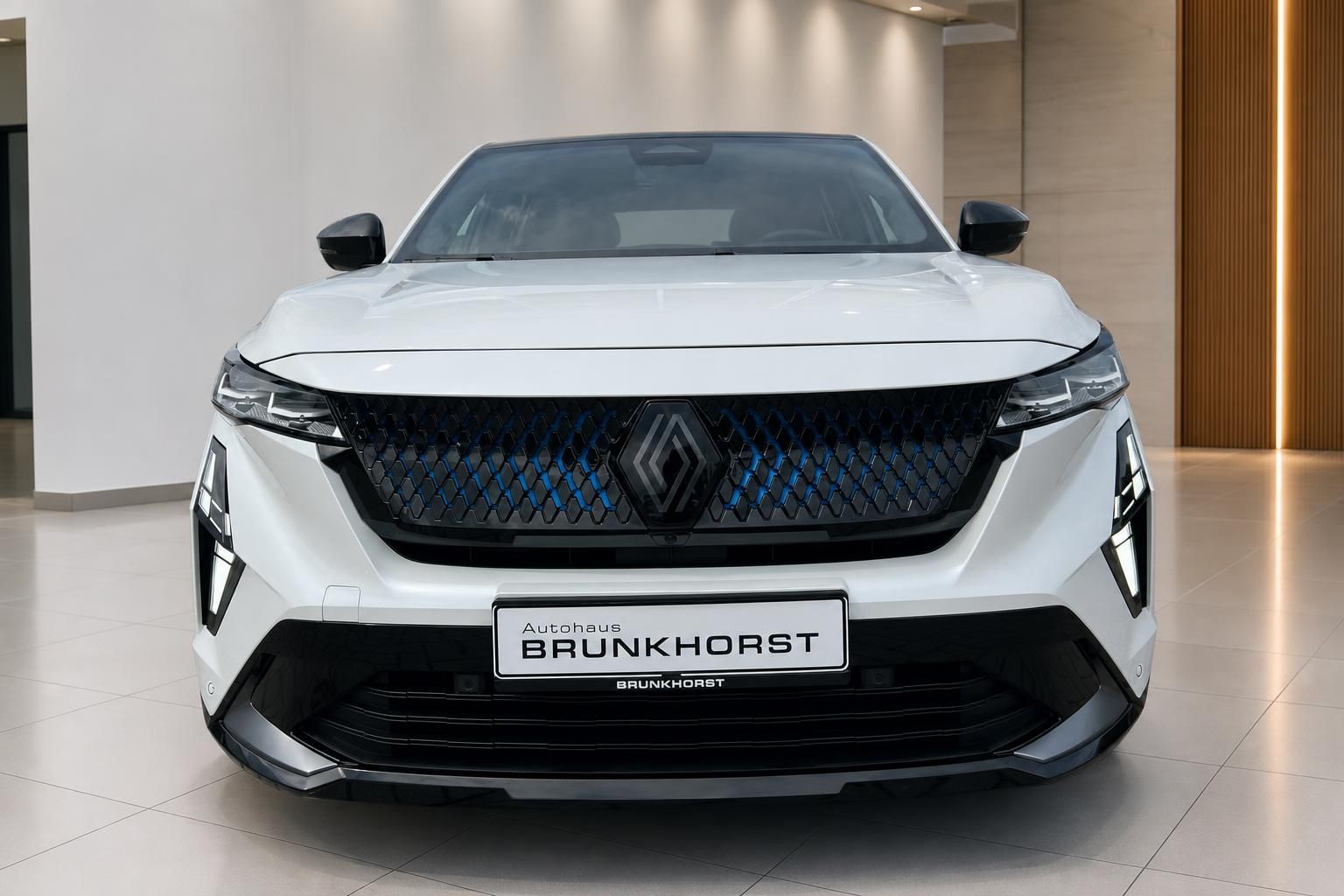 Renault Rafale E-Tech Hybrid weiss Frontansicht mit blauem Kühlergrill im Autohaus