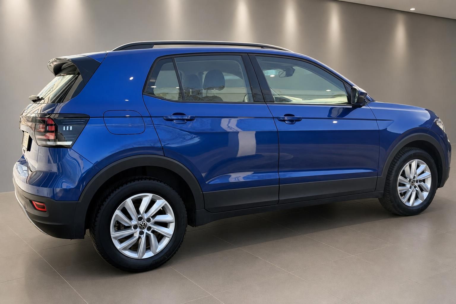 VW T-Cross blau, Seitenansicht im Showroom mit Alufelgen