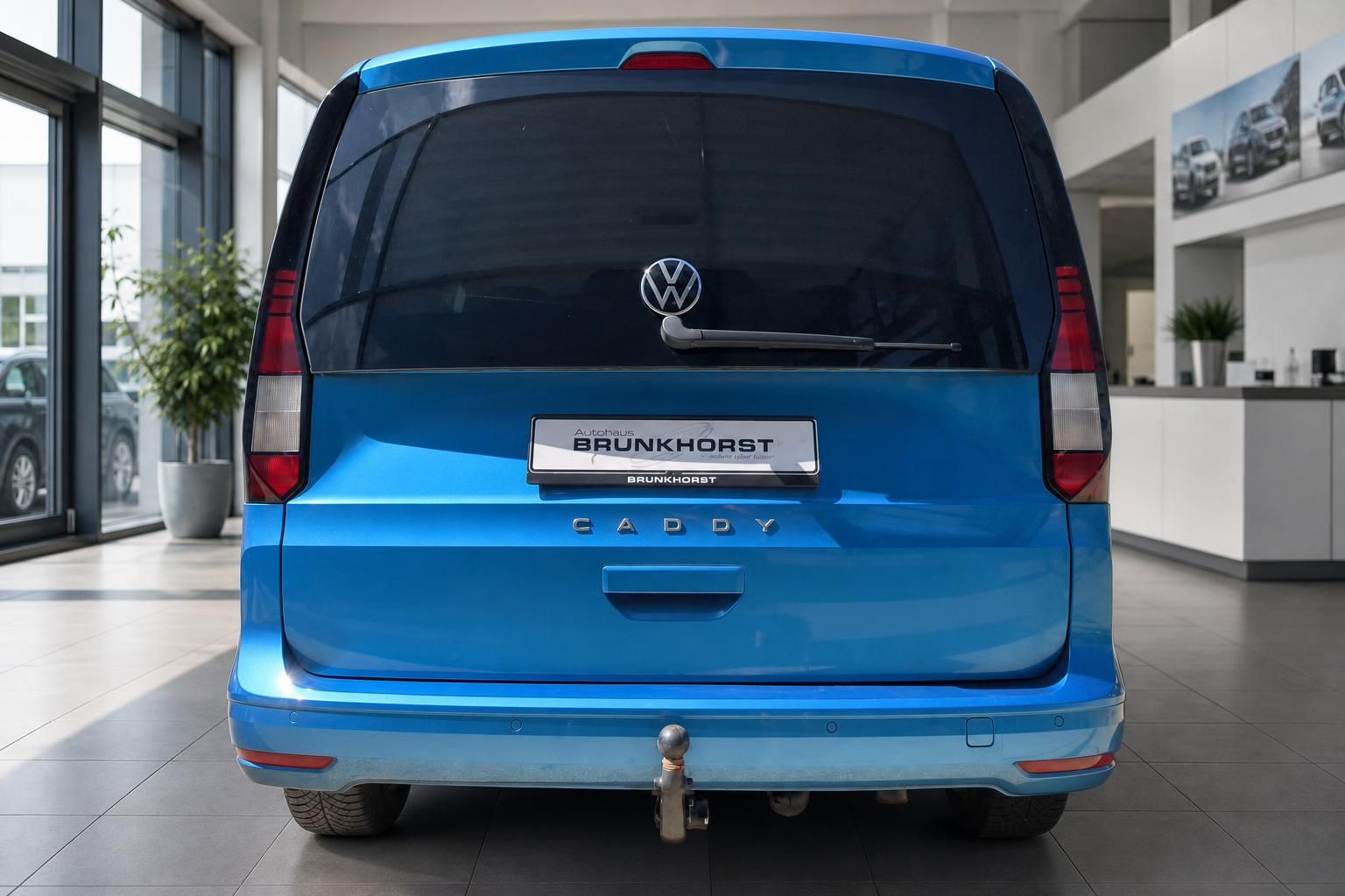 Volkswagen Caddy blau Heckansicht mit BRUNKHORST Kennzeichenhalter im Autohaus Showroom