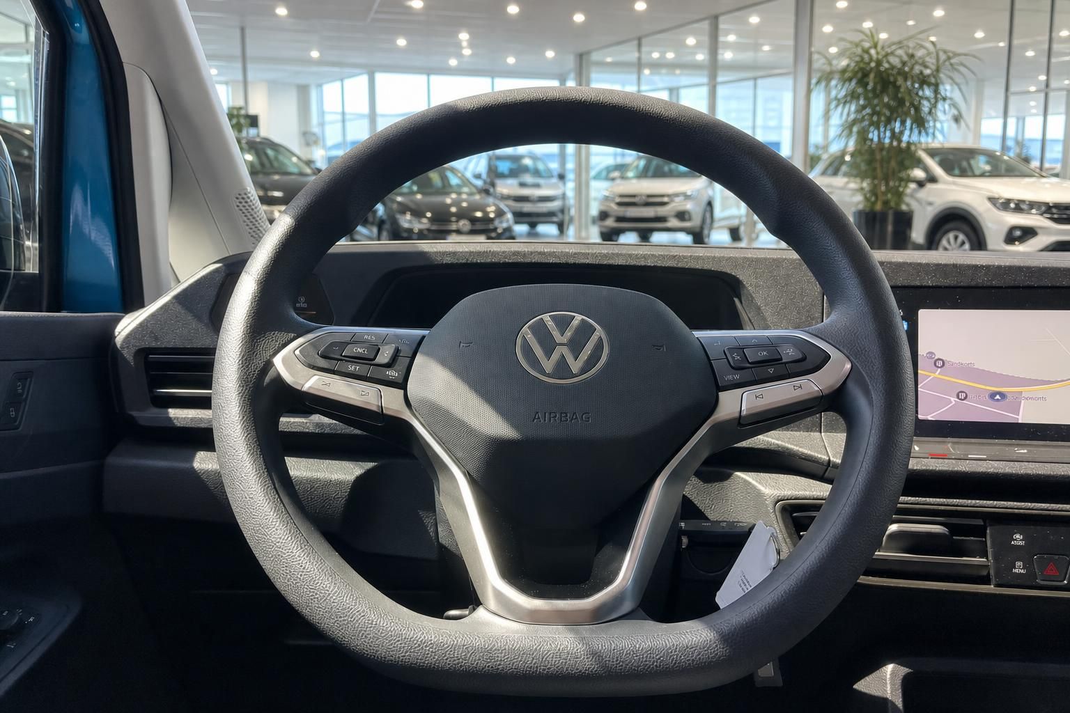 Volkswagen Lenkrad mit VW Logo und Airbag Kennzeichnung im Fahrzeug Innenraum