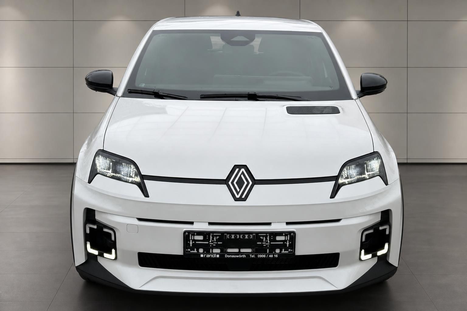 Renault 5 in Weiss, Frontalansicht mit LED-Scheinwerfern im Autohaus