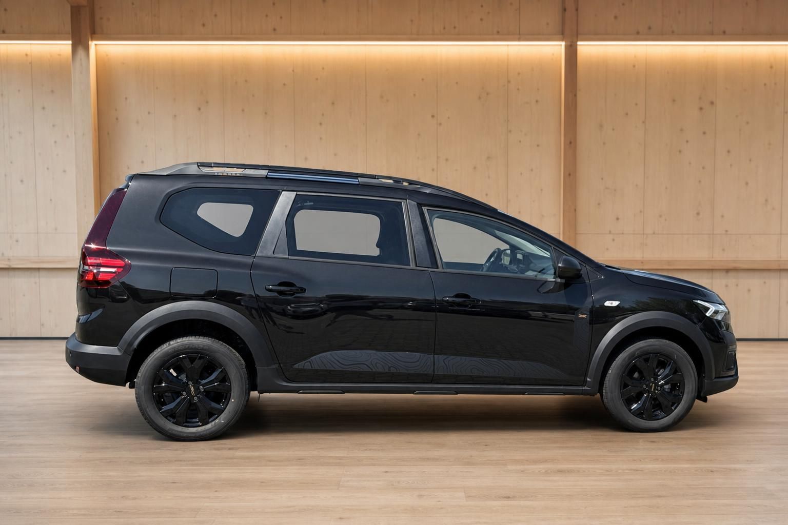Dacia Jogger schwarz Seitenansicht mit schwarzen Alufelgen im Showroom