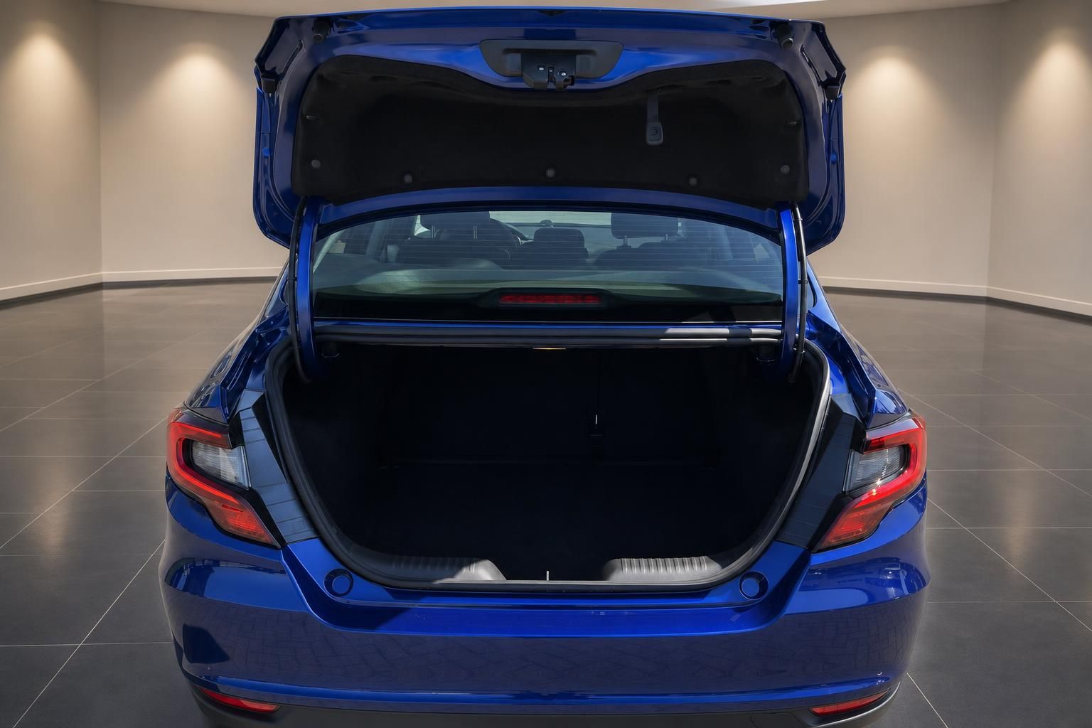 Blauer Pkw Sedan mit geöffnetem Kofferraum von hinten im Autohaus