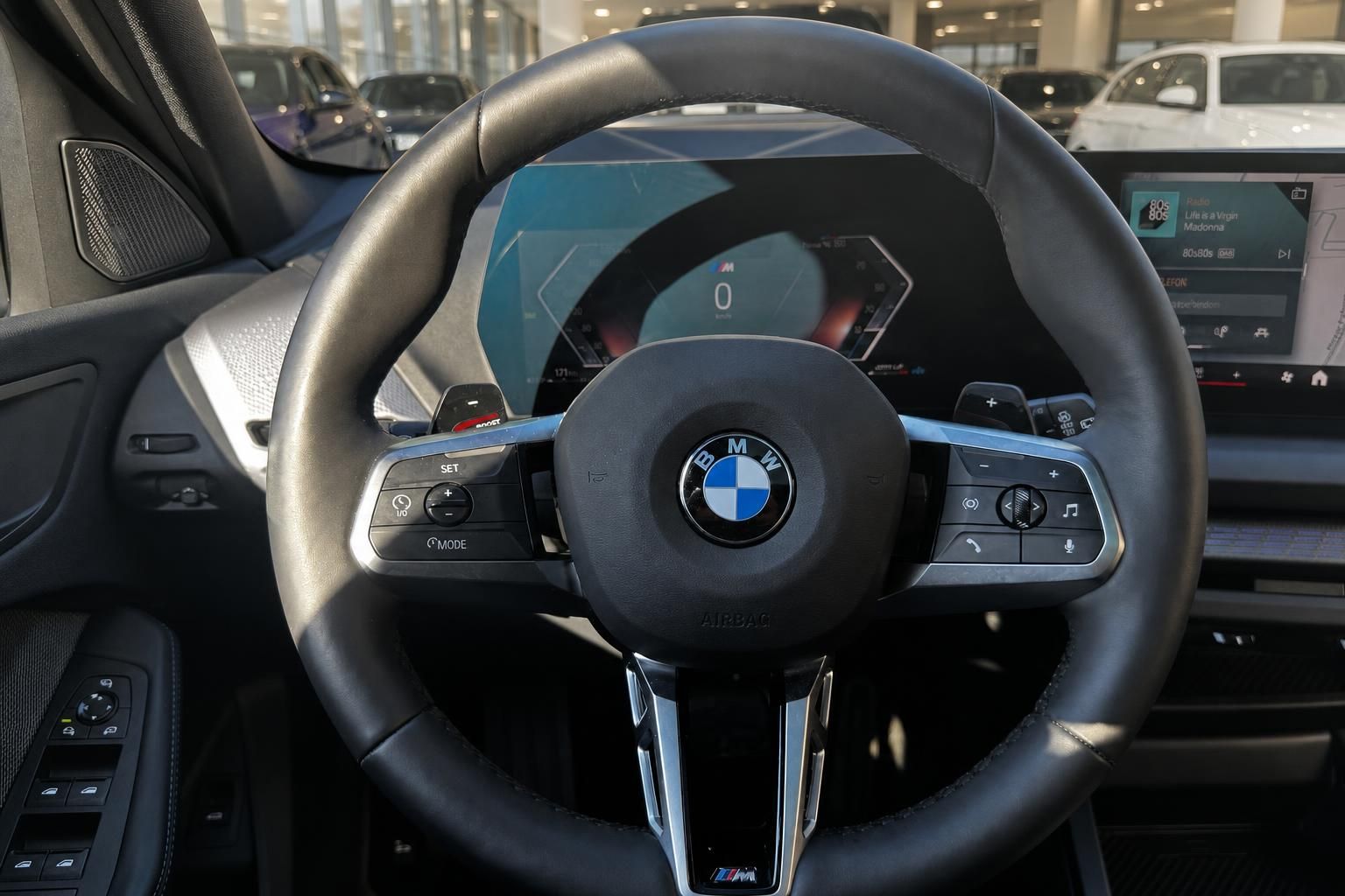 BMW M Lenkrad Innenraum mit digitalem Cockpit und Infotainment-Display im Autohaus