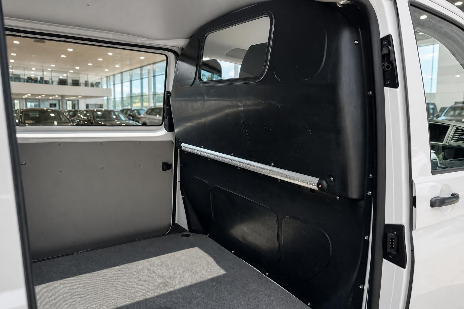 Laderaum eines weißen Transporters mit schwarzer Verkleidung und LED-Lichtleiste im Autohaus