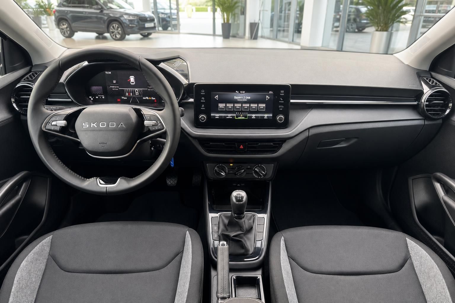 Skoda Innenraum mit Lenkrad, Infotainment-Display, Schaltgetriebe und grauen Stoffsitzen