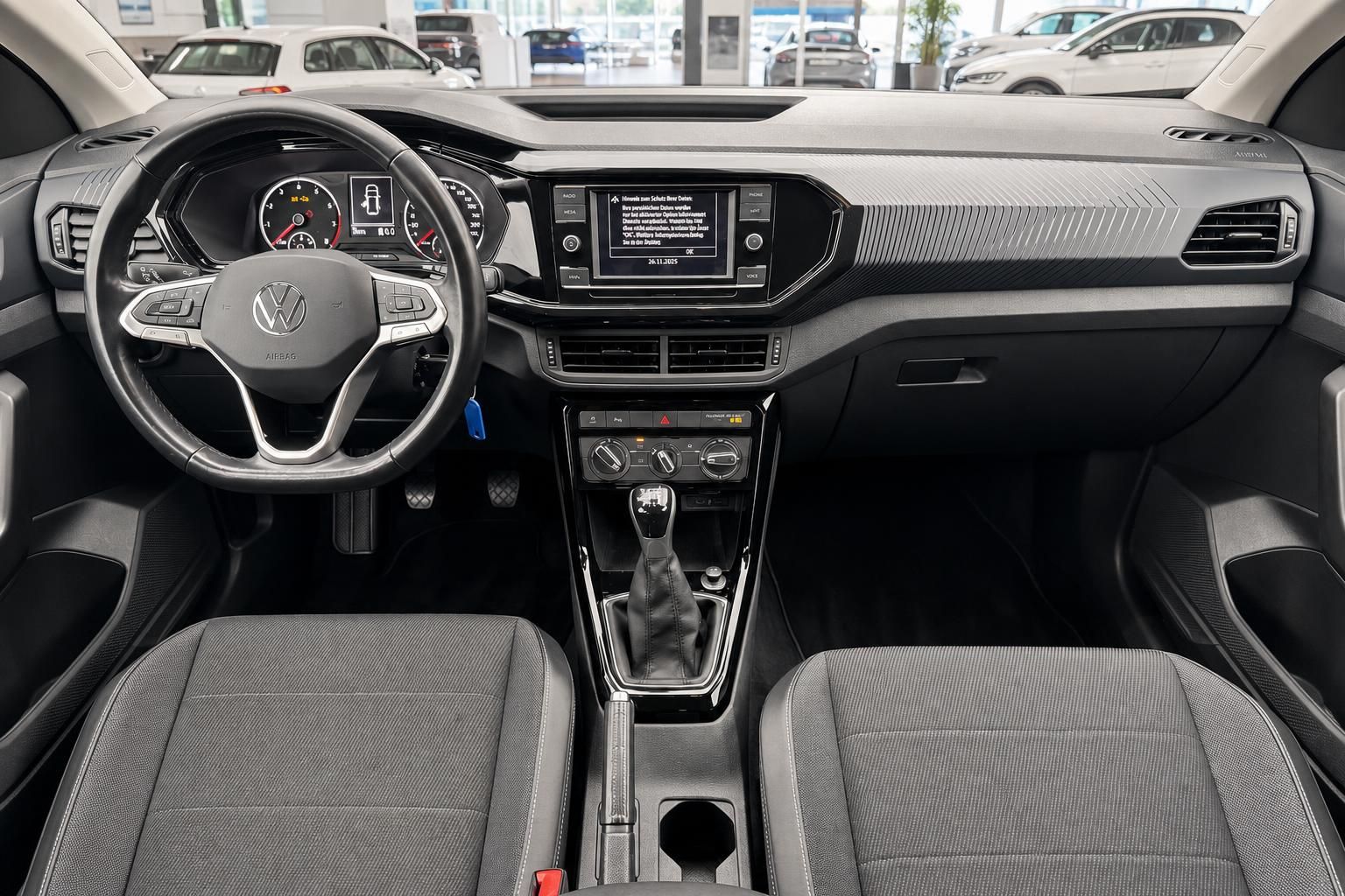 VW T-Cross Innenraum – Cockpit mit Lenkrad, Infotainment, Schaltgetriebe und Stoffsitzen in Grau