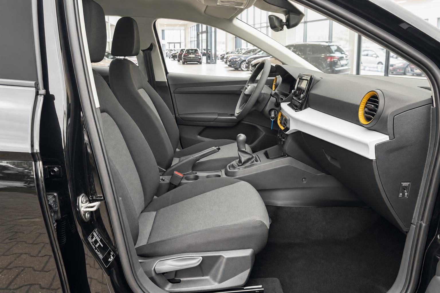 SEAT Arona Innenraum – Vordersitze, Schaltgetriebe und Armaturenbrett mit gelben Akzenten