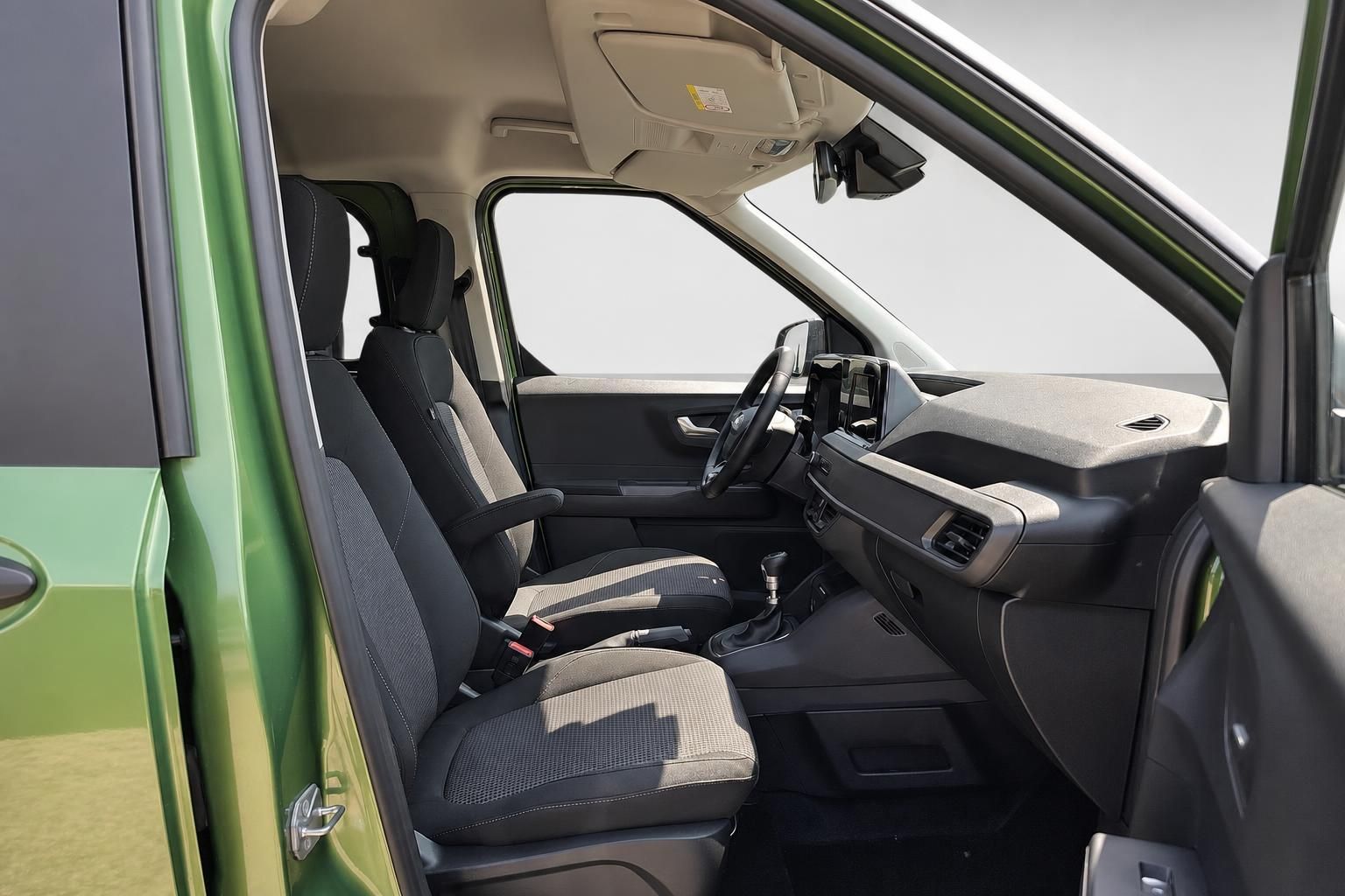 Innenraum eines grünen Van mit schwarzen Sitzen und Cockpit