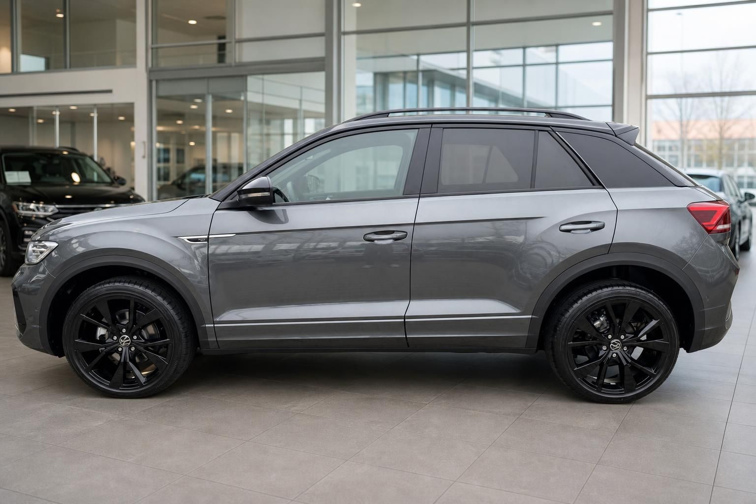 VW T-Roc grau Seitenansicht mit schwarzen Felgen im Autohaus