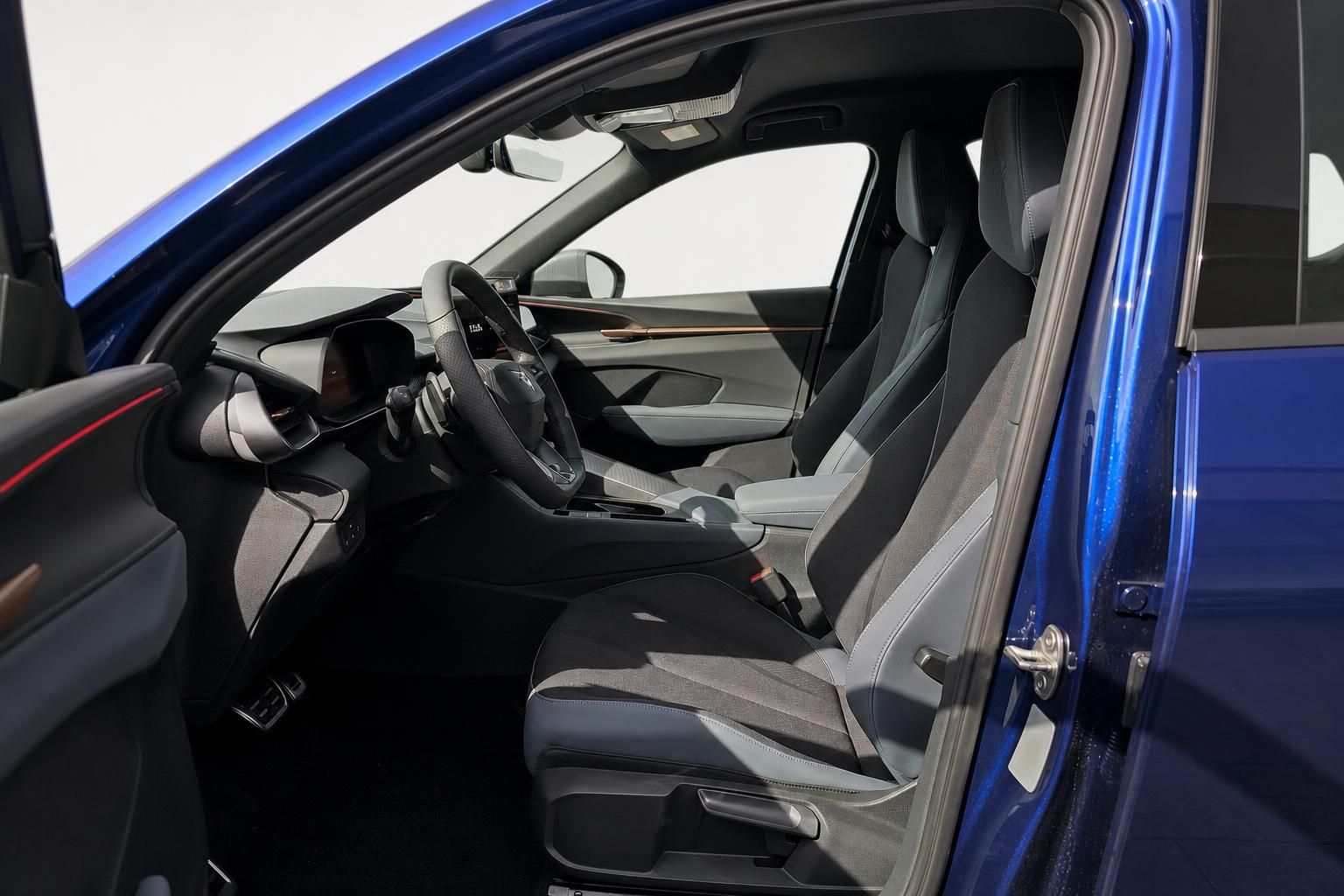 Innenraum eines blauen Fahrzeugs mit Blick auf Vordersitze und Cockpit