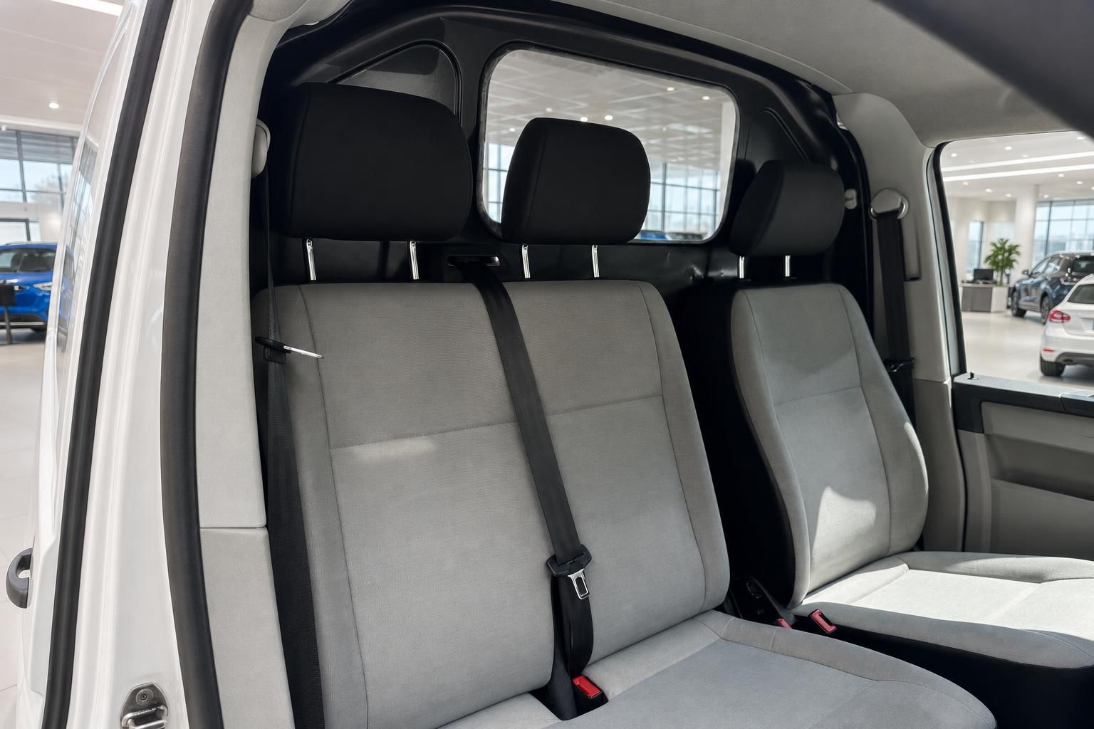 VW Caddy Innenraum Rücksitzbank grau mit Sicherheitsgurt und Trennwand im Autohaus