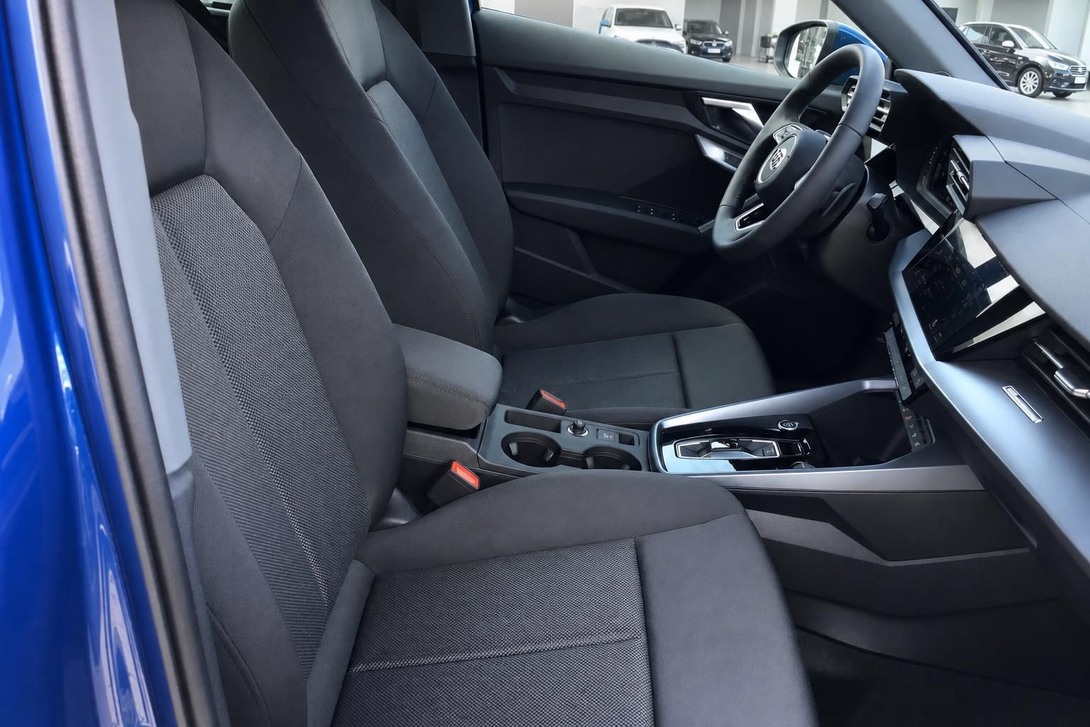 Audi Innenraum Vordersitze mit schwarzem Stoffbezug, Mittelkonsole und Touchscreen-Infotainment