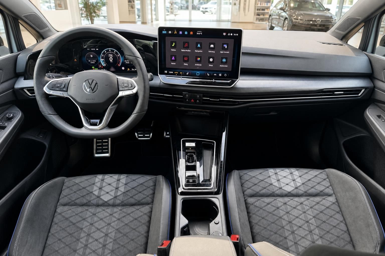 VW Golf Innenraum mit Cockpit, Touchscreen, Lenkrad und Sportsitzen in grauem Interieur