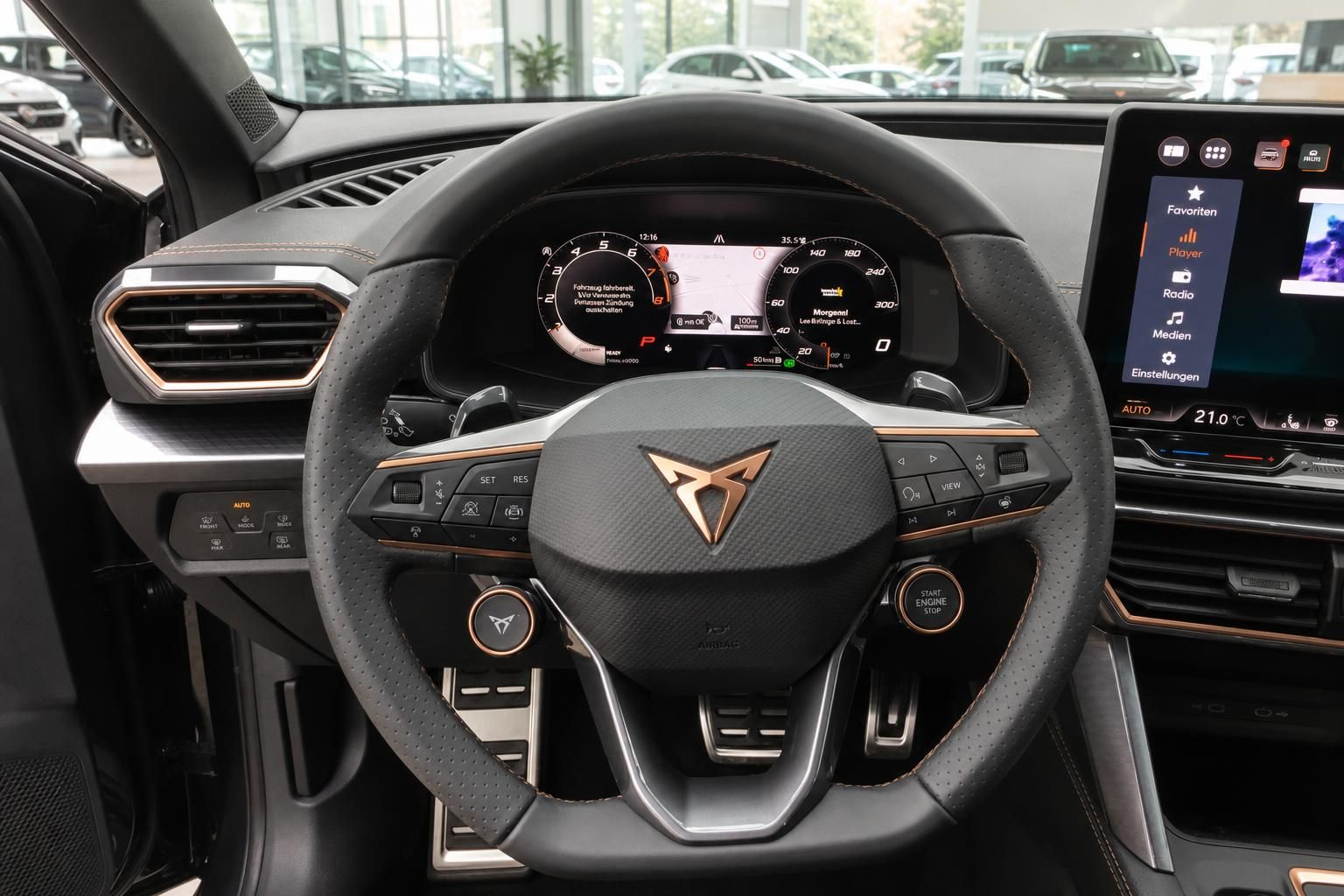 CUPRA Innenraum Lenkrad mit goldenem Logo, digitales Cockpit und Infotainment-Display