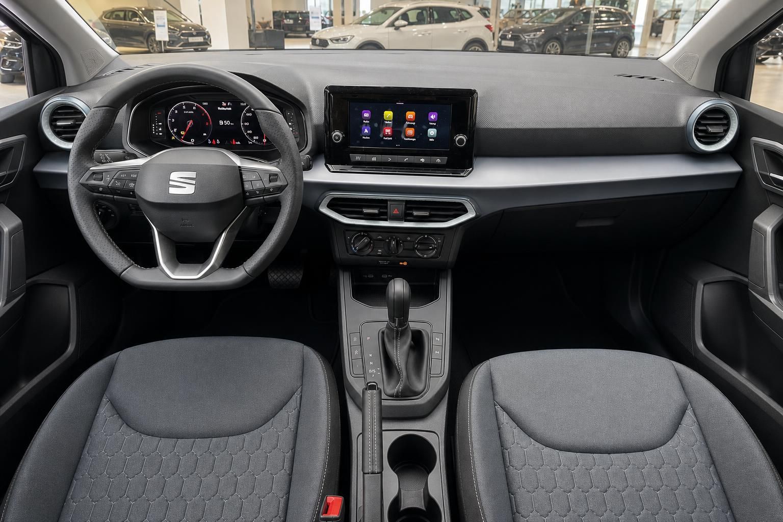 SEAT Innenraum mit Lenkrad, Touchscreen-Infotainment und grauen Stoffsitzen – Cockpit Detailansicht