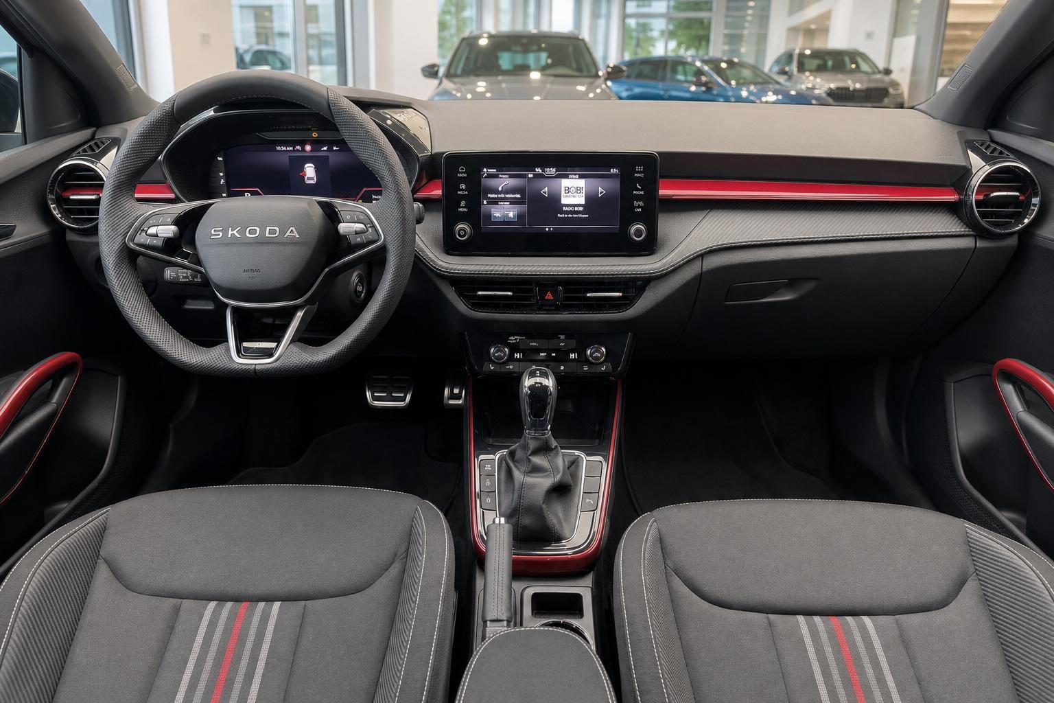 Skoda Innenraum Cockpit mit Lenkrad, Touchscreen, Schaltgetriebe und roten Akzenten