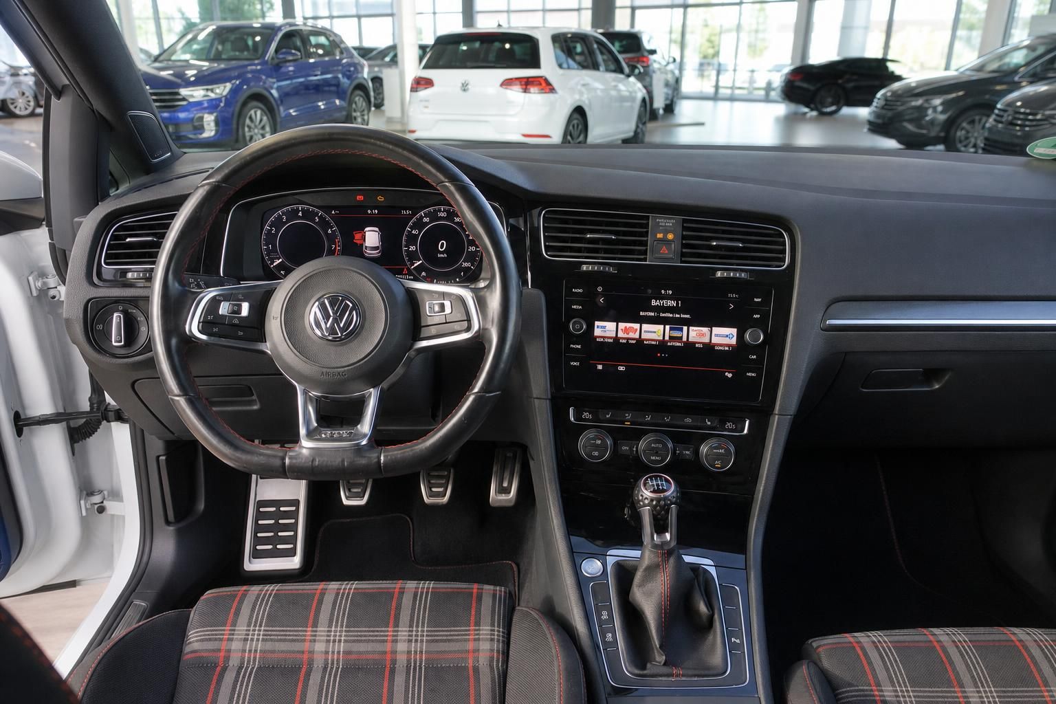 VW Golf GTI Innenraum mit Lenkrad, Schaltknüppel, Infotainment und GTI-Karositzstoff