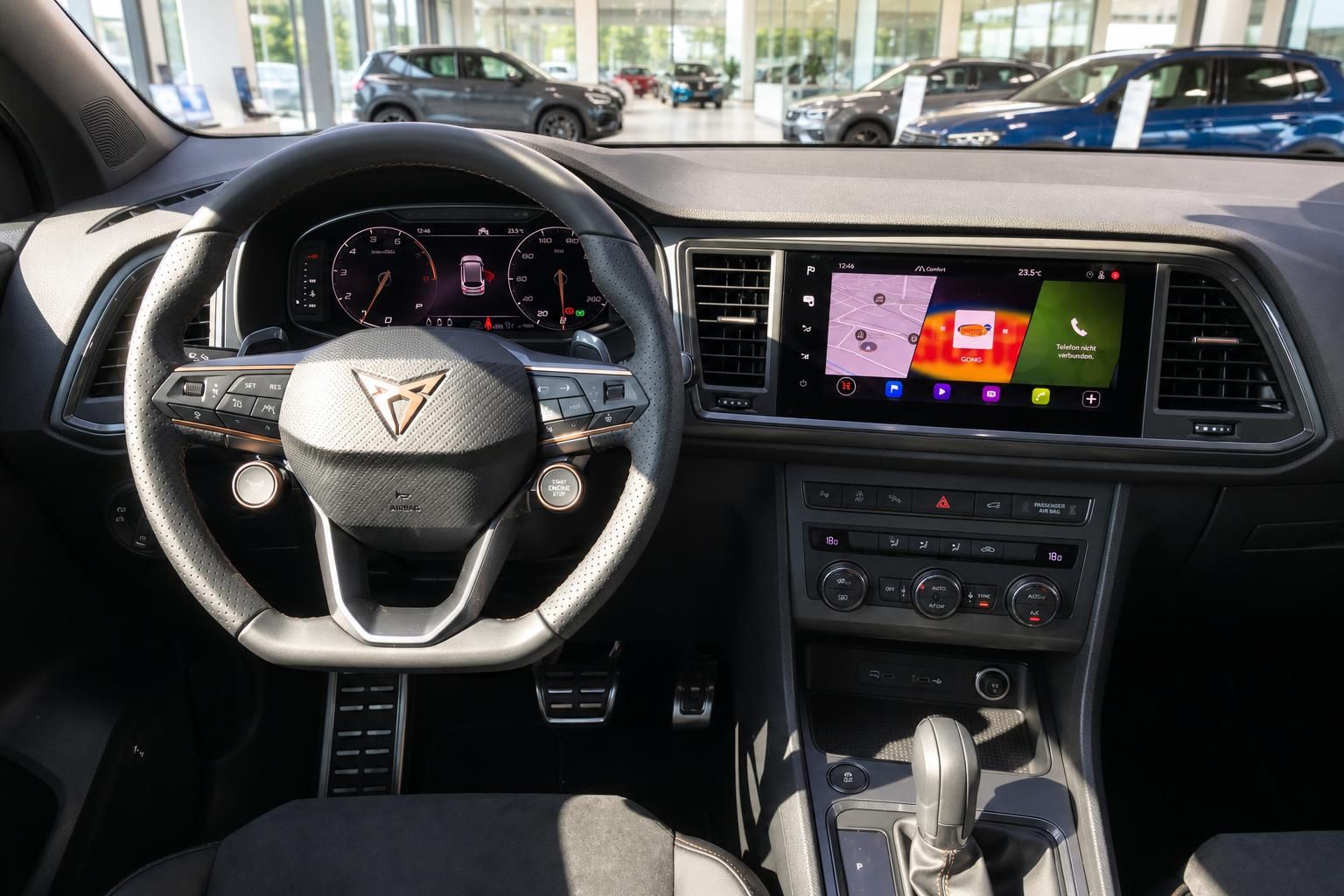 CUPRA Innenraum mit Lenkrad, digitalem Cockpit und Infotainment-Display im Autohaus