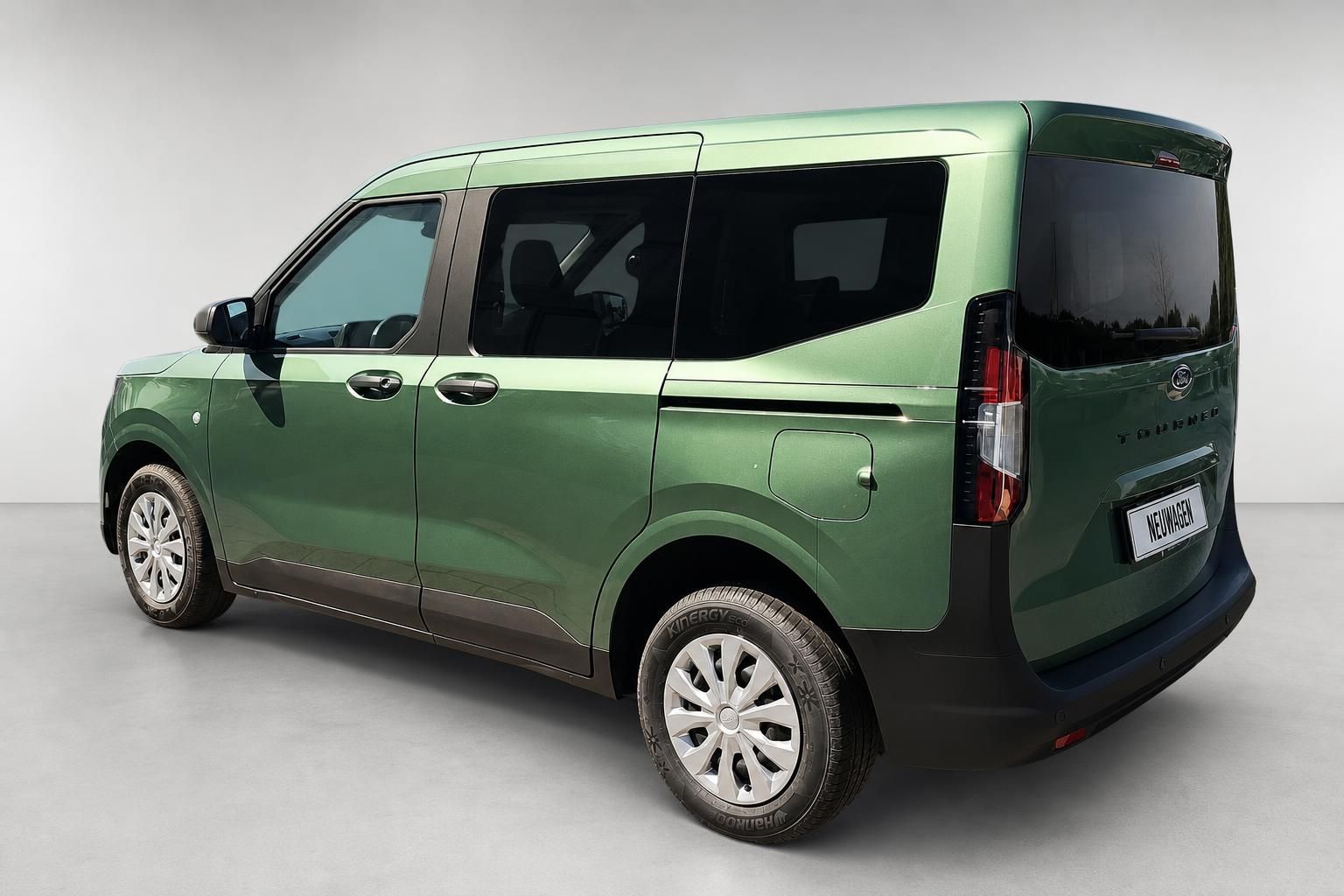 Ford Tourneo Courier in Gruen metallic, Heckansicht schraeg im Studio