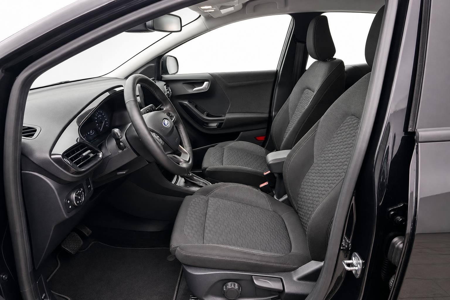 Innenraum Ford mit schwarzen Stoffsitzen und Blick auf Lenkrad und Cockpit