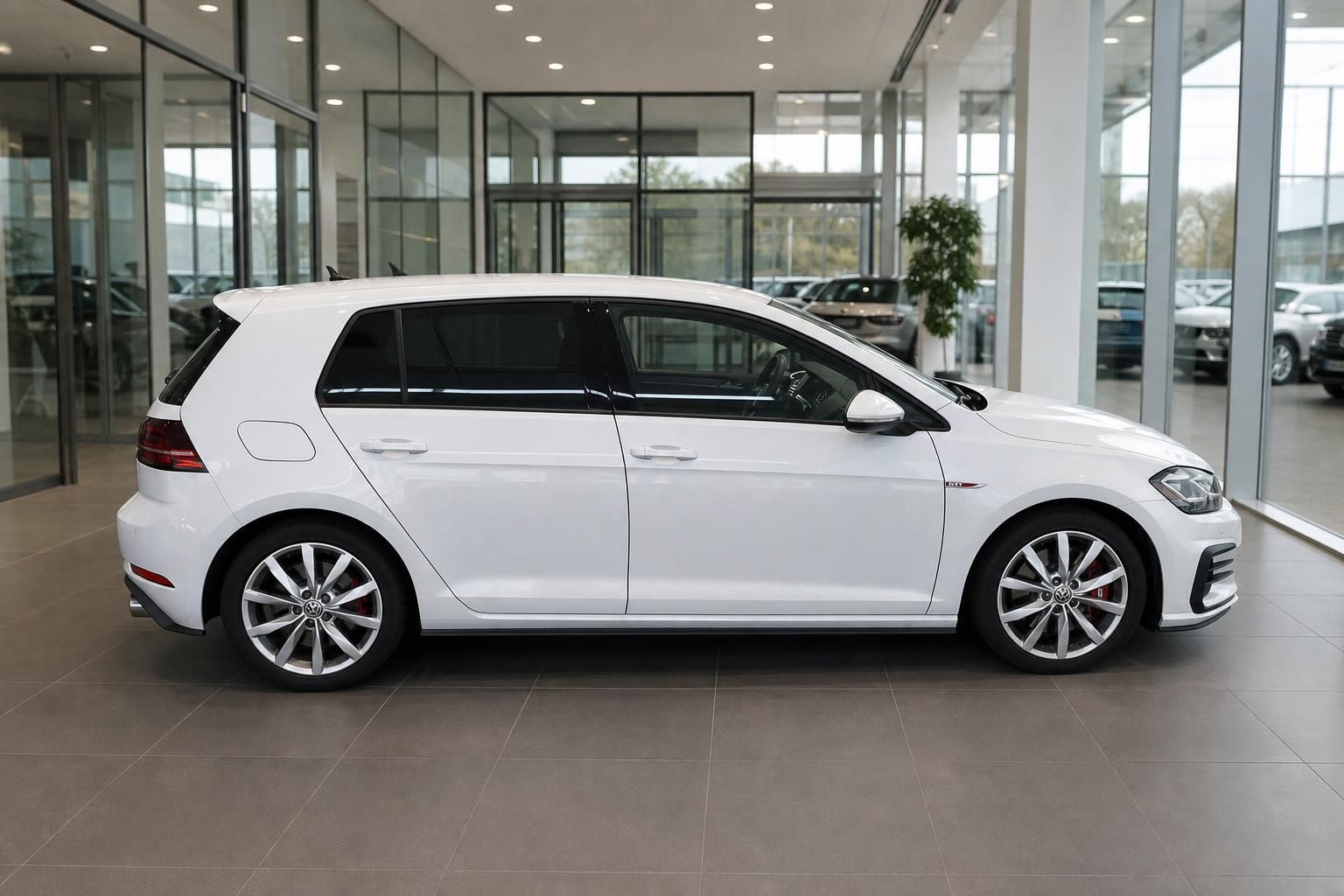 VW Golf GTI weiss Seitenansicht im Autohaus – gepflegter Kompaktsportwagen mit Alufelgen