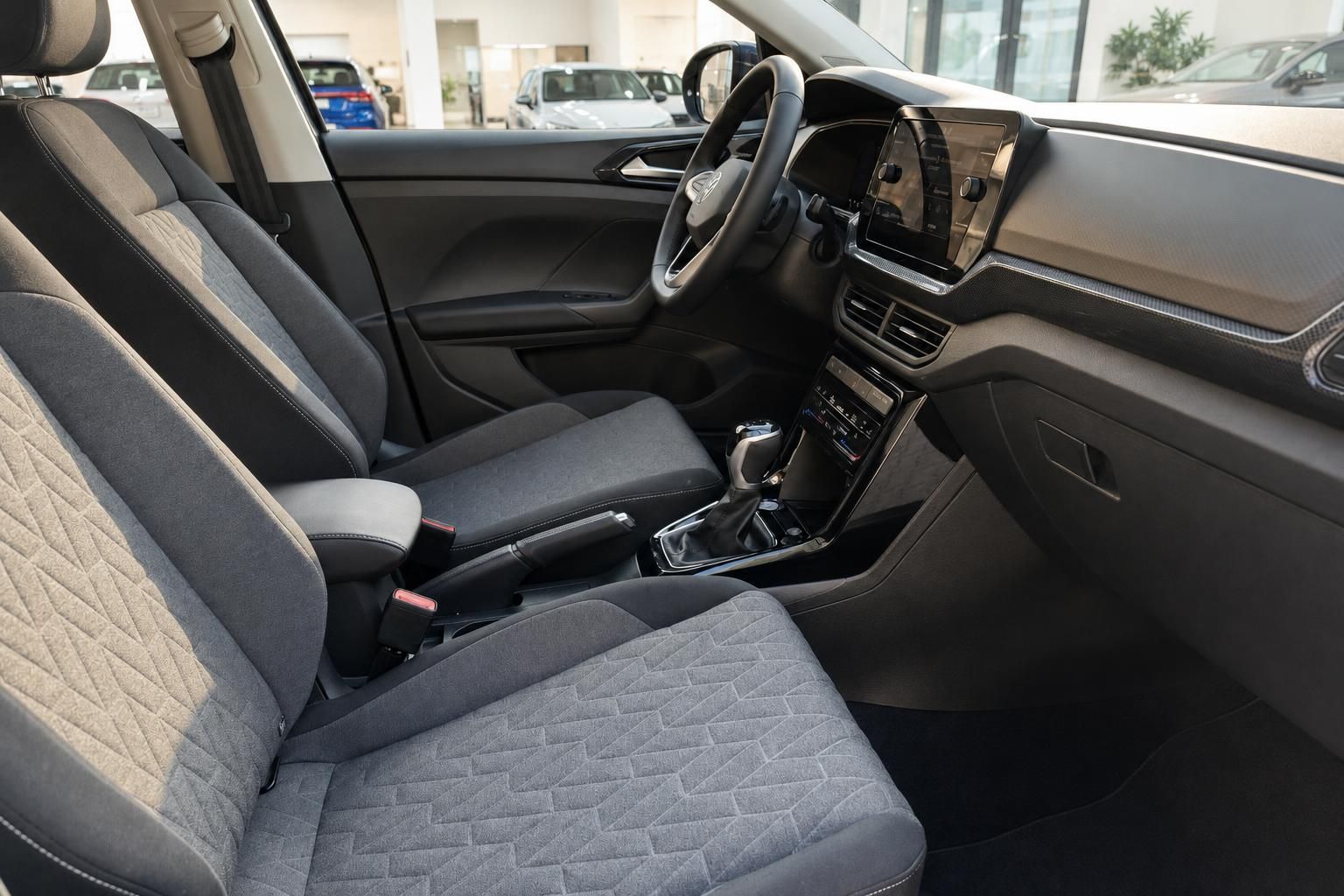VW Innenraum Vordersitze grau mit Mittelkonsole, Lenkrad und Touchscreen-Navi im Autohaus