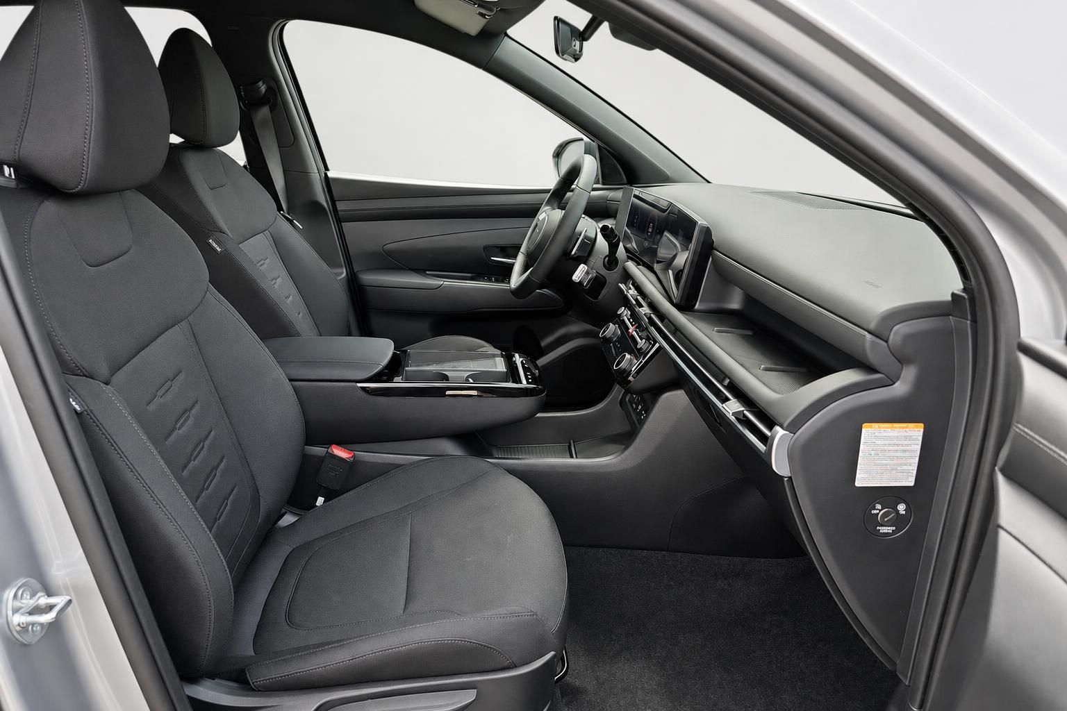 Innenraum mit schwarzen Stoffsitzen, Lenkrad und Cockpit im Detail