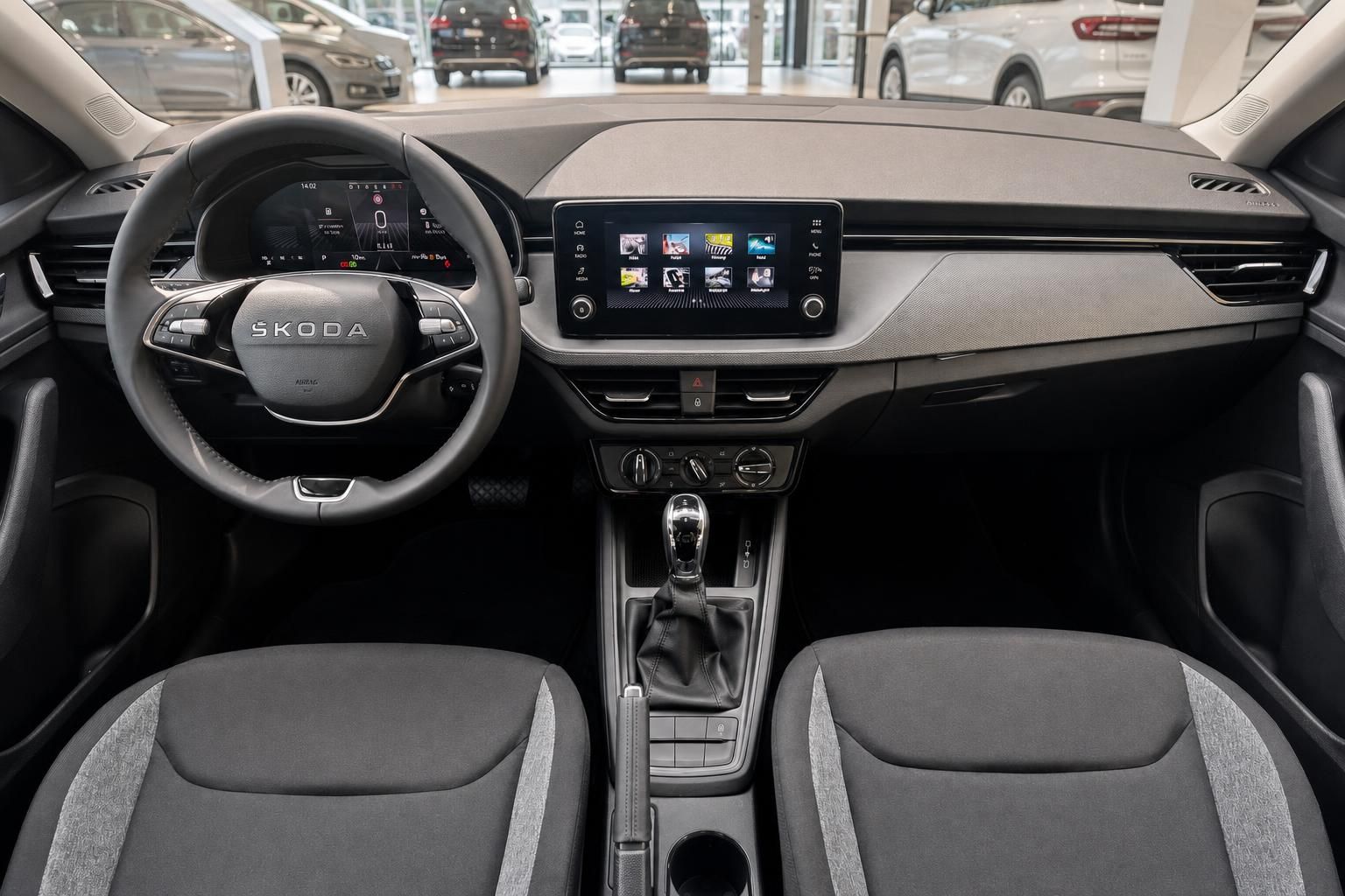 Skoda Innenraum mit Lenkrad, Infotainment-Display, Mittelkonsole und Vordersitzen in Grau