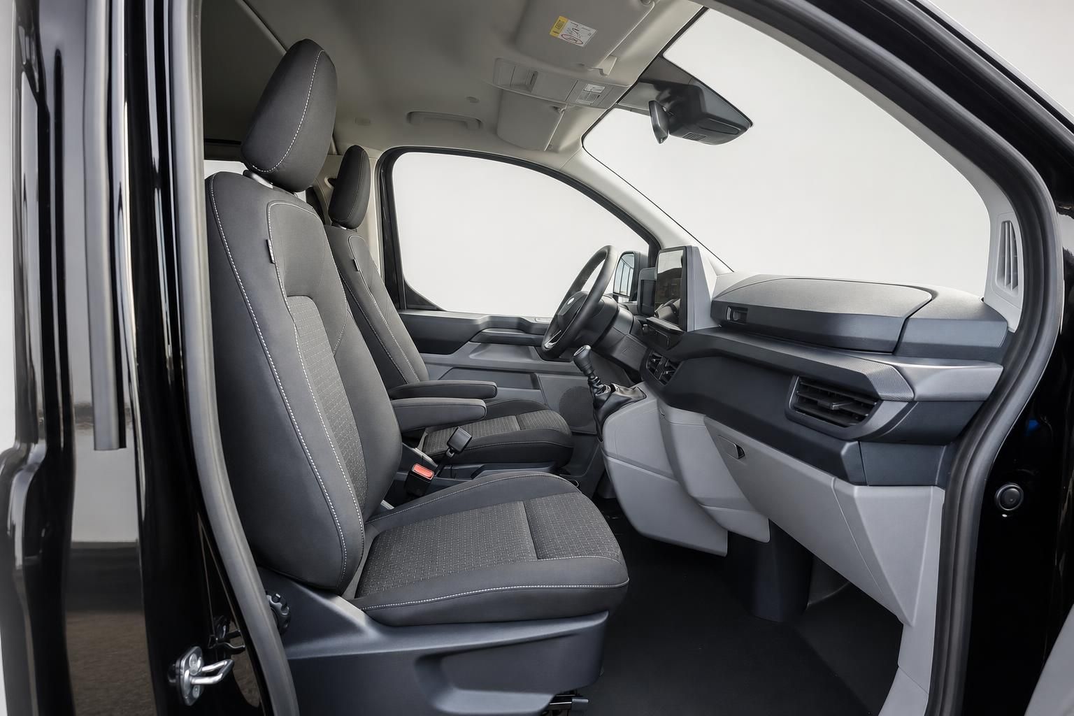 Innenraum eines Transporters mit Vordersitzen und Cockpit in Schwarz-Grau