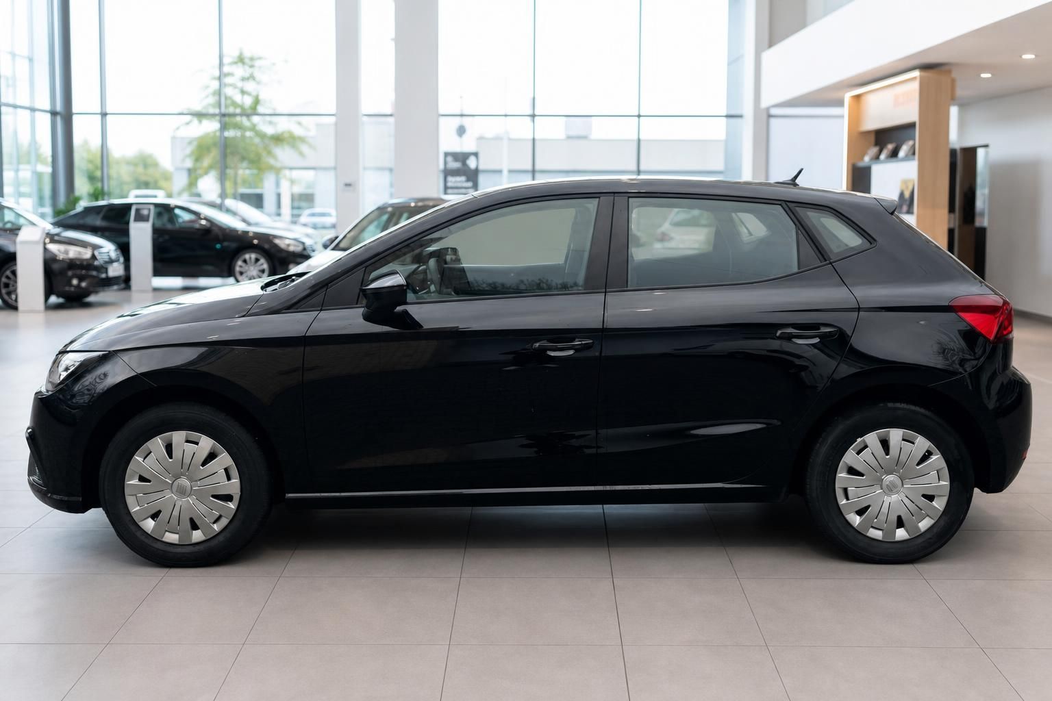 Schwarzer SEAT Ibiza Kleinwagen in der Seitenansicht in moderner Fahrzeughalle