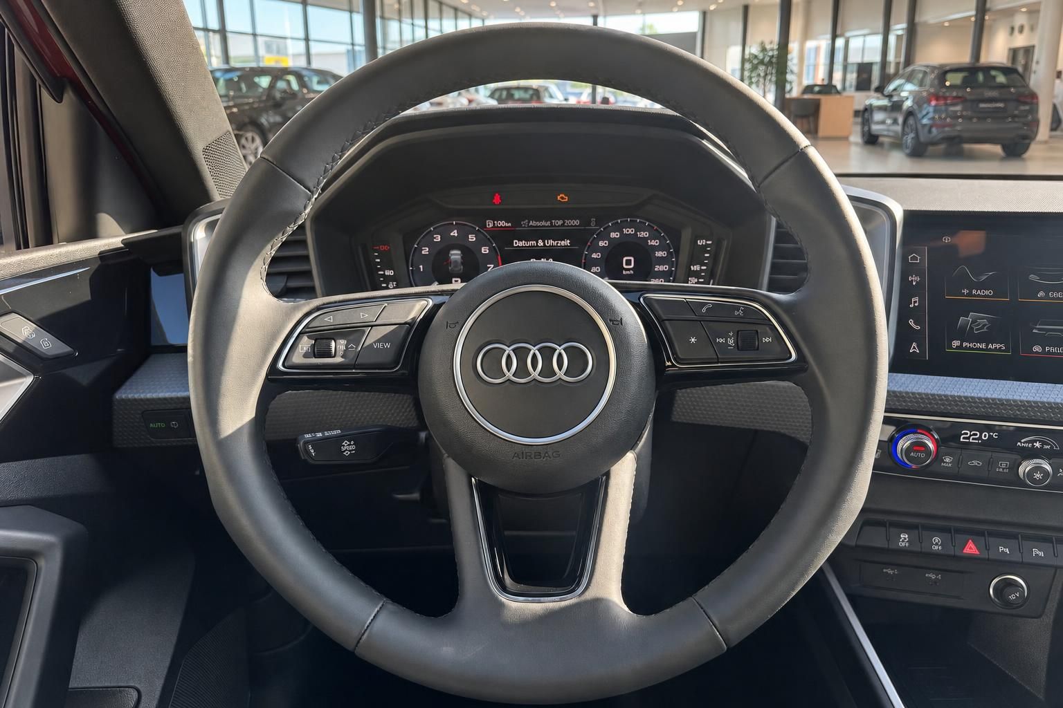 Audi Innenraum Lenkrad mit Vierring-Logo, digitales Cockpit und MMI Touchscreen im Autohaus