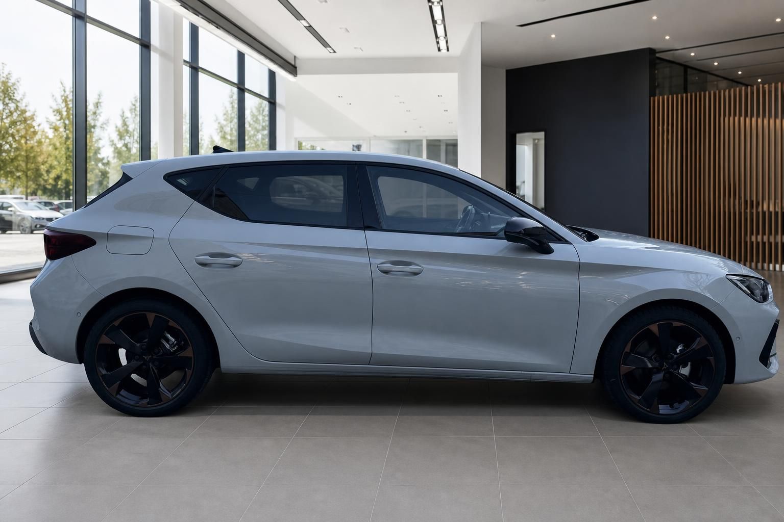 Cupra Leon Kompaktsportler in Hellgrau mit schwarzen Felgen, Seitenansicht im Autohaus