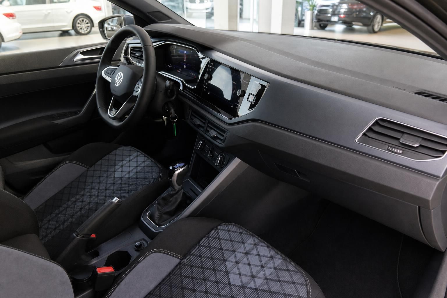 VW Innenraum mit Lenkrad, Digitaltacho, Infotainment-Display und Sportsitzen in Schwarz-Grau
