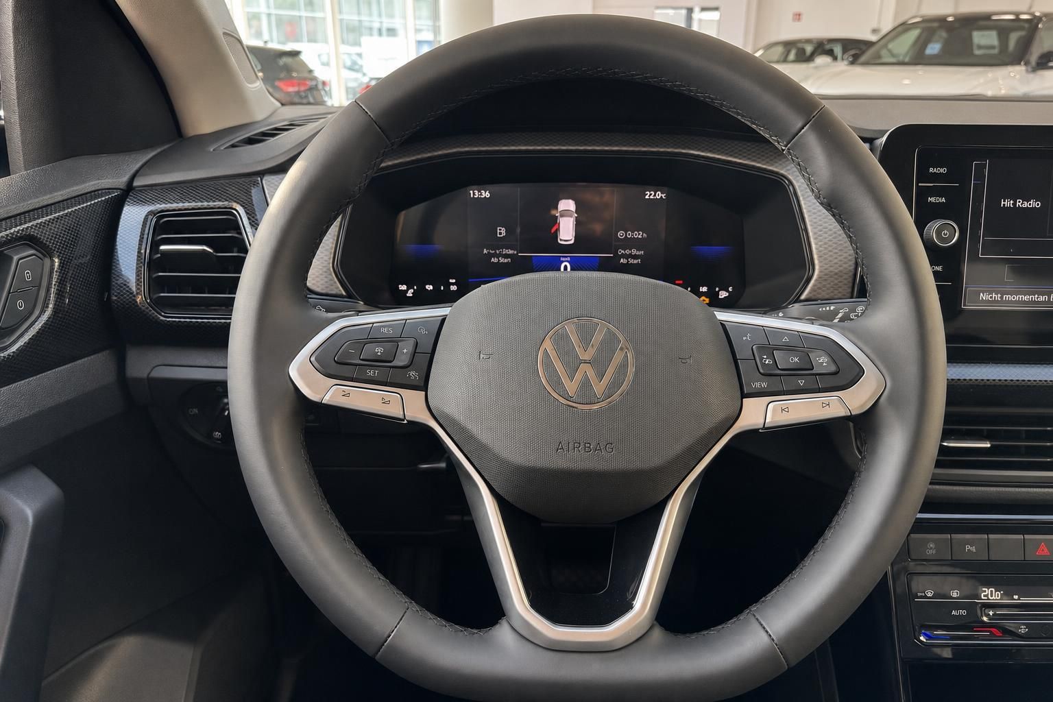 VW Lenkrad mit Multifunktionstasten und digitalem Cockpit im Innenraum