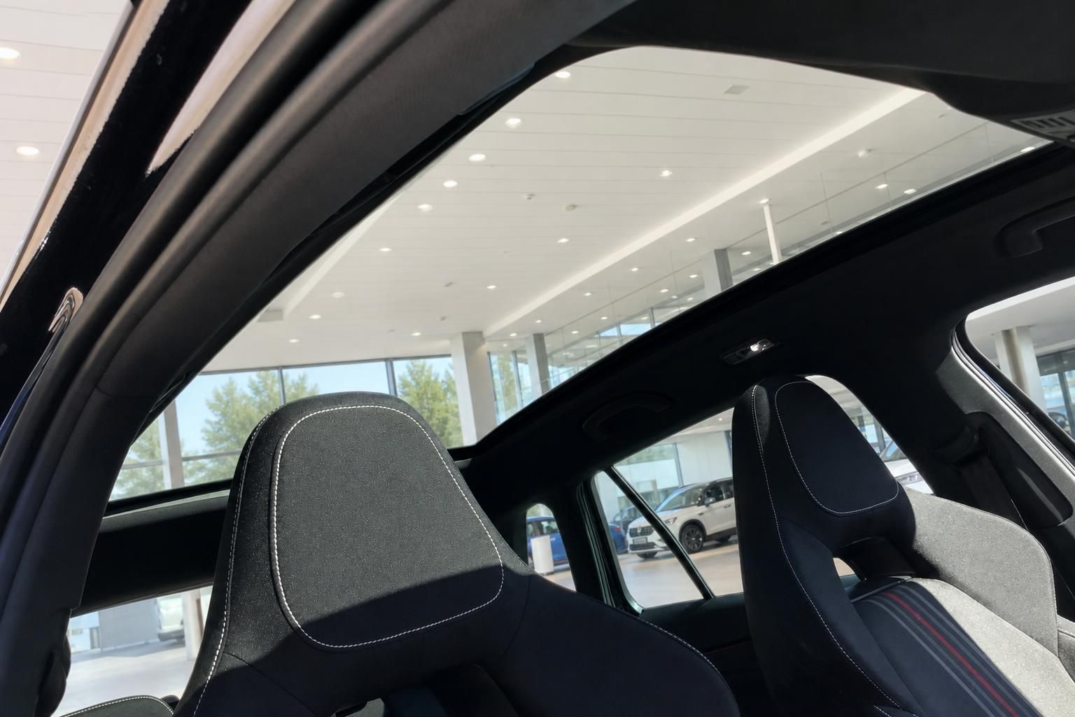 Fahrzeug Innenraum mit schwarzen Sportsitzen und Panorama-Glasdach im Autohaus