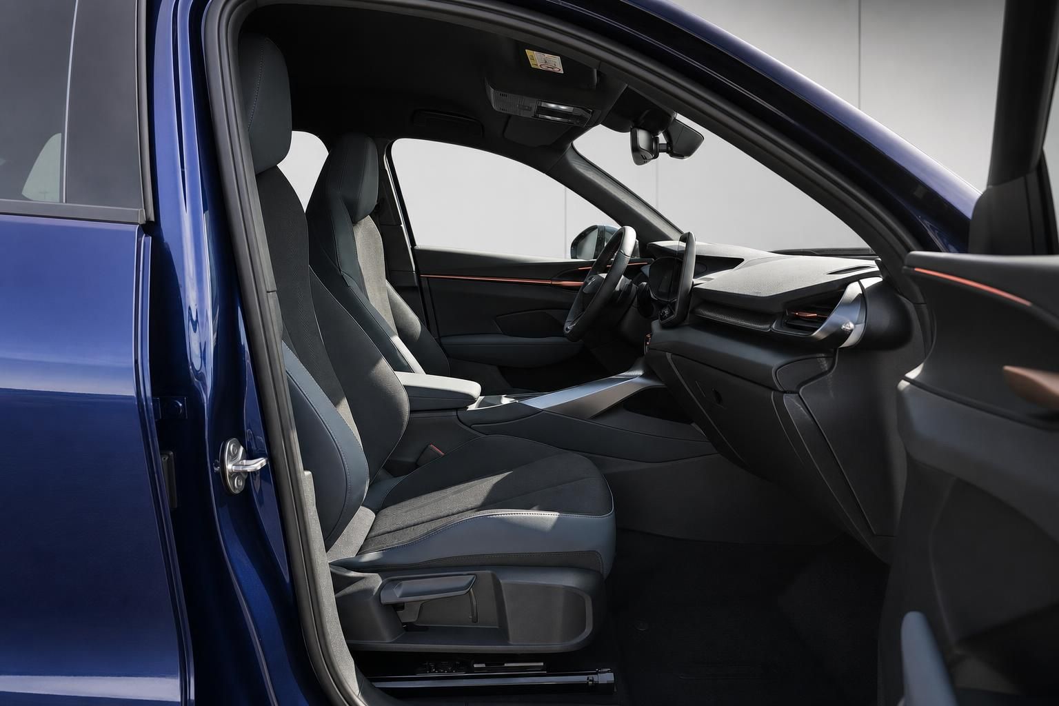 Innenraum eines blauen Fahrzeugs mit Blick auf Vordersitze und Cockpit